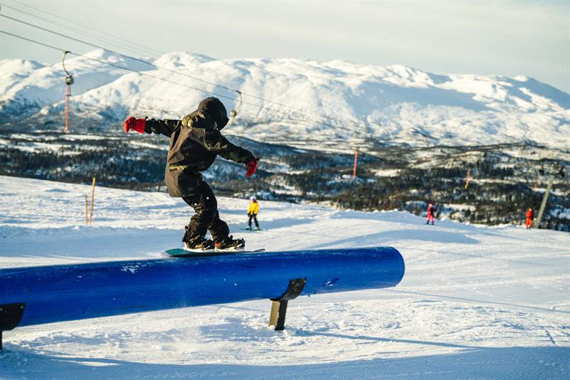 with snowboard in terrain park to Rauland ski center