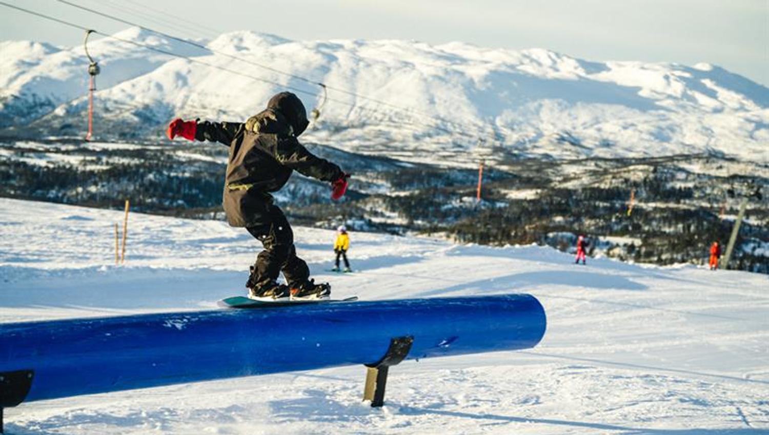 with snowboard in terrain park to Rauland ski center