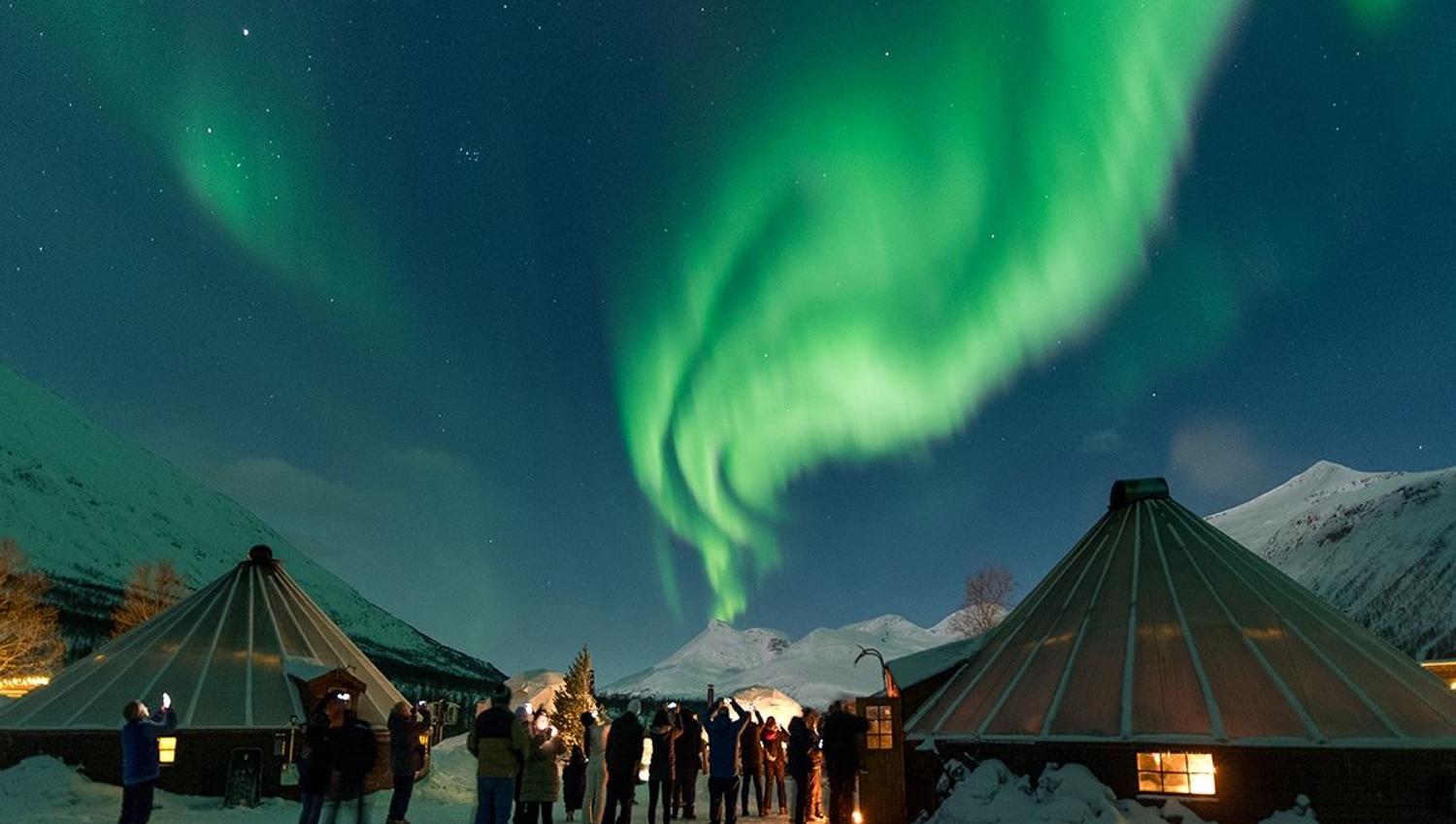 The Northern Lights shine over the camp