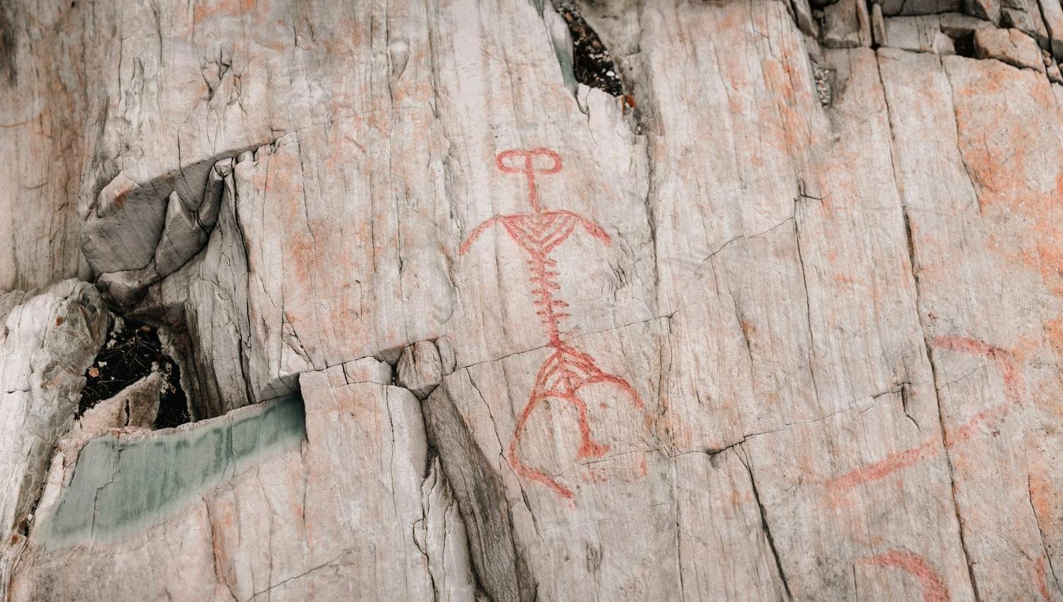 A red-painted petroglyph depicting a deer on a rock surface in Vingen.
