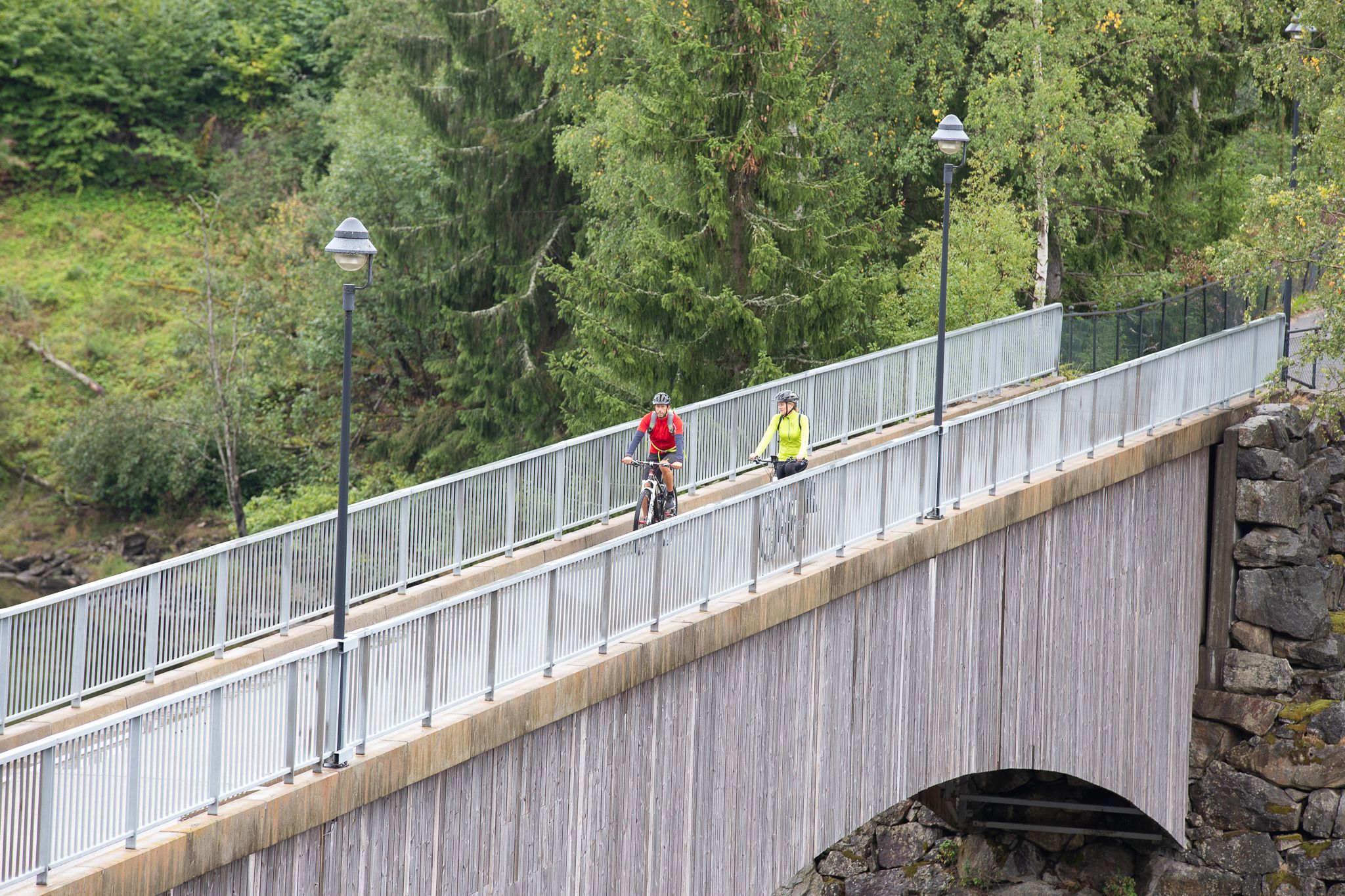A couple going by bike across a bridge