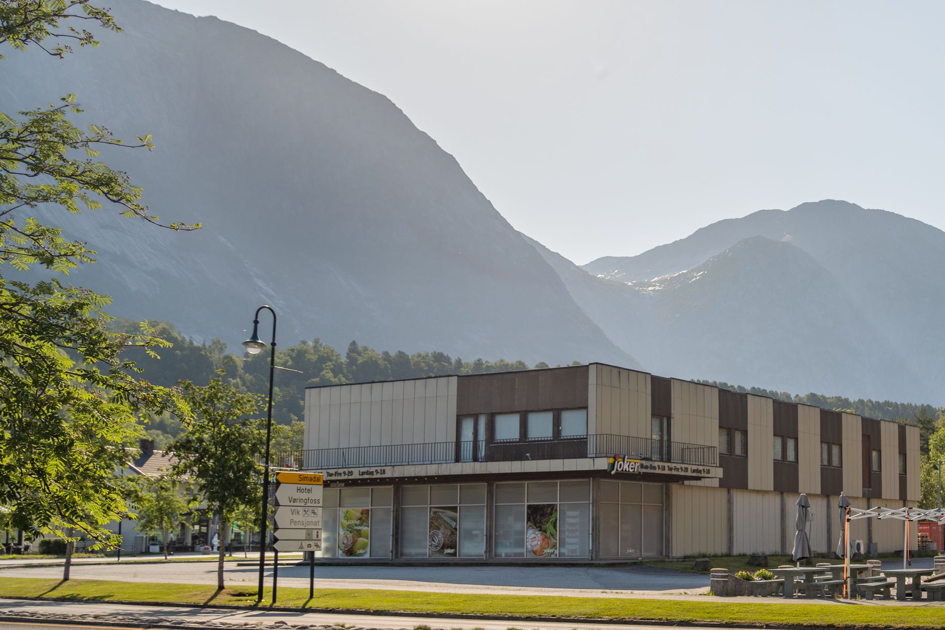 Joker grocery store from the outside, with high mountain in the background on a sunny day.