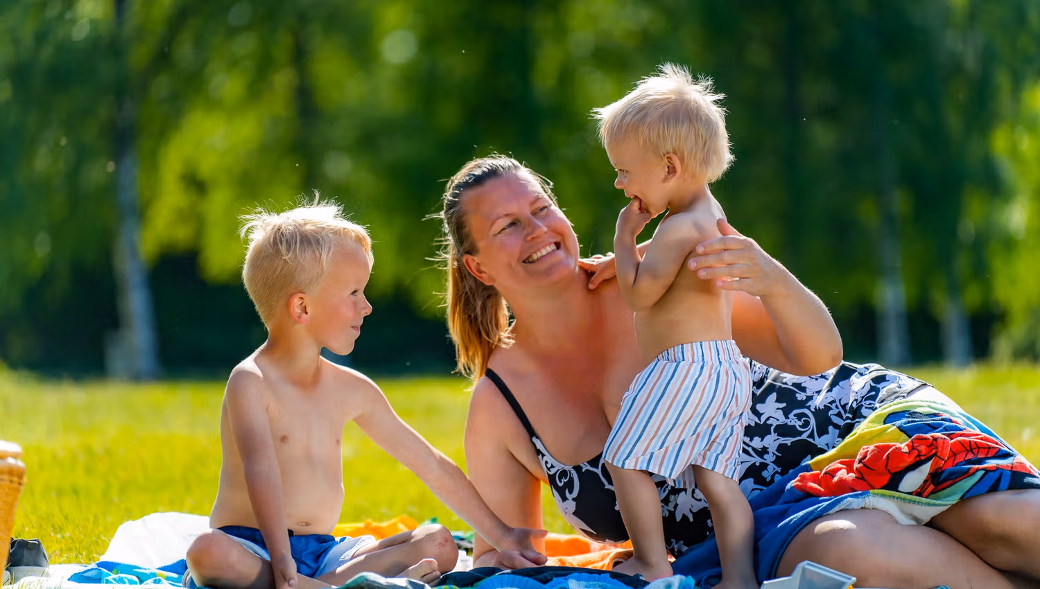 Mor og barn som koser seg sammen på stranda