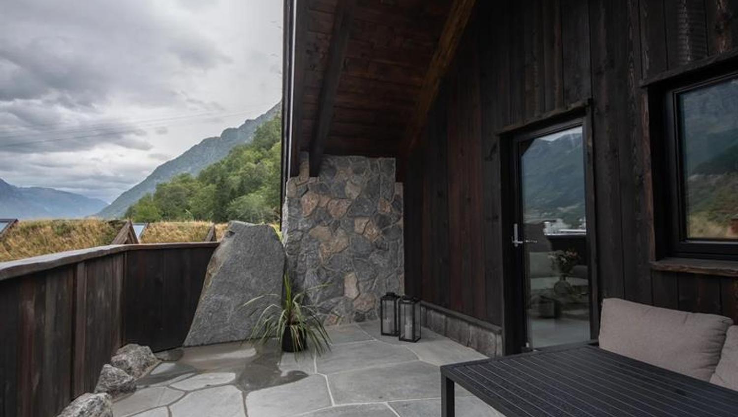 Privat uteareal med steinheller og fjellutsikt utanfor vikinghytte på Lothepus Camping i Odda