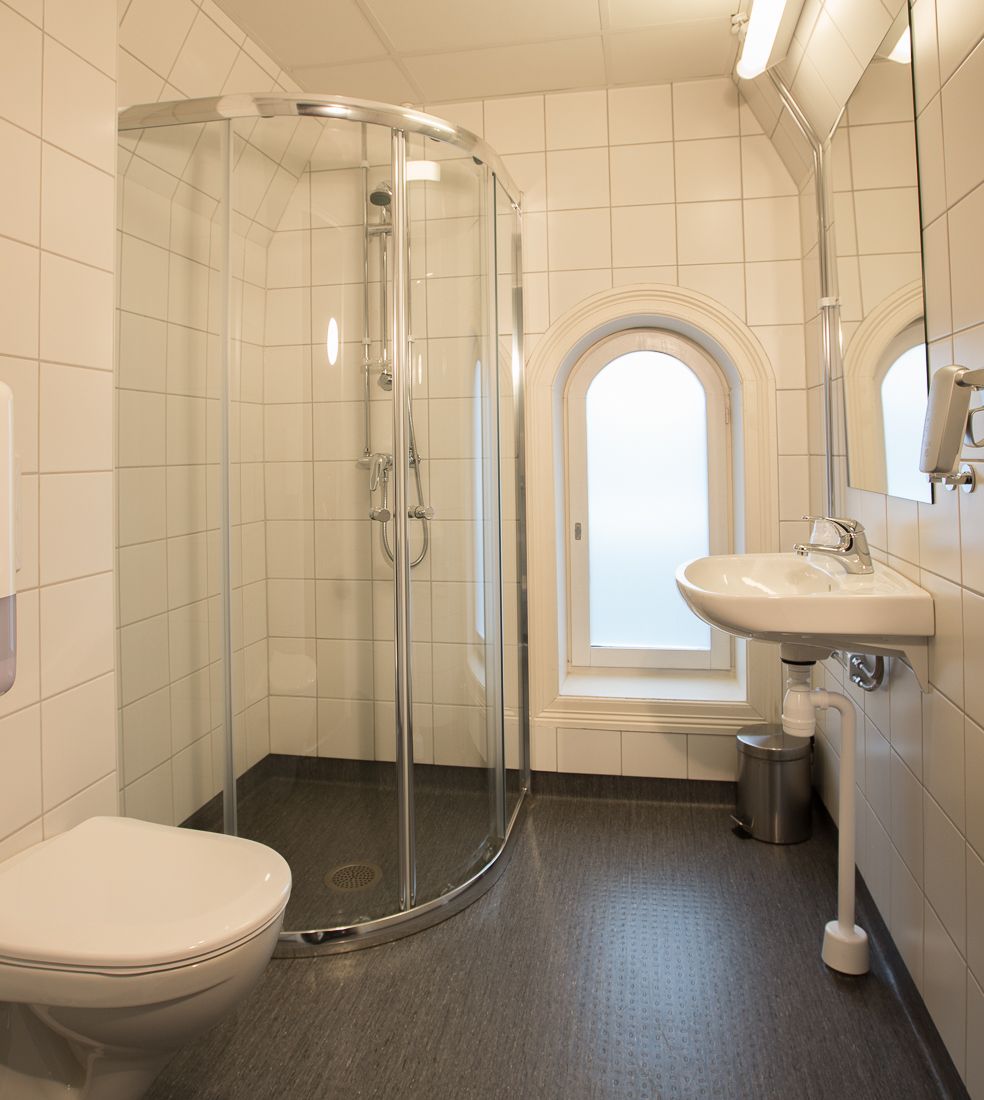 Bathroom with glass shower cabinet. White tiles. Saga Hotel & Poshtel Oslo Central. Photo