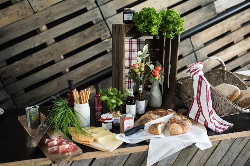 Detaljbilde av diverse brød, ost og skinker.