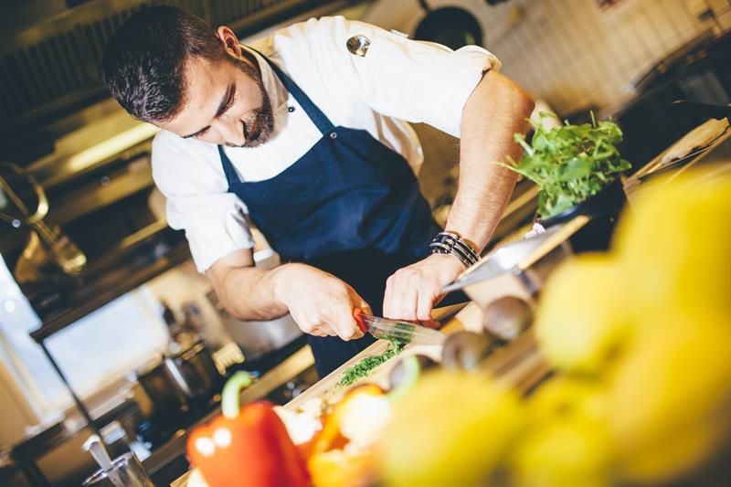 A skilled chef prepares delicious dishes using fresh, local ingredients at Tyssedal Hotel.