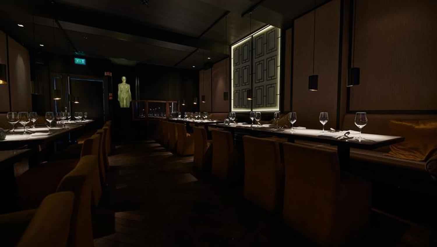 Tables set for dining, chairs, and seating sections against the wall, glass sculpture at the end of the room
