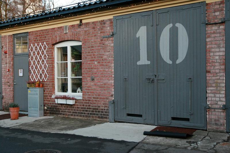 Mursteinsfasade med store grå dører merket «10» ved Nummer Ti på Karljohansvern i Horten.