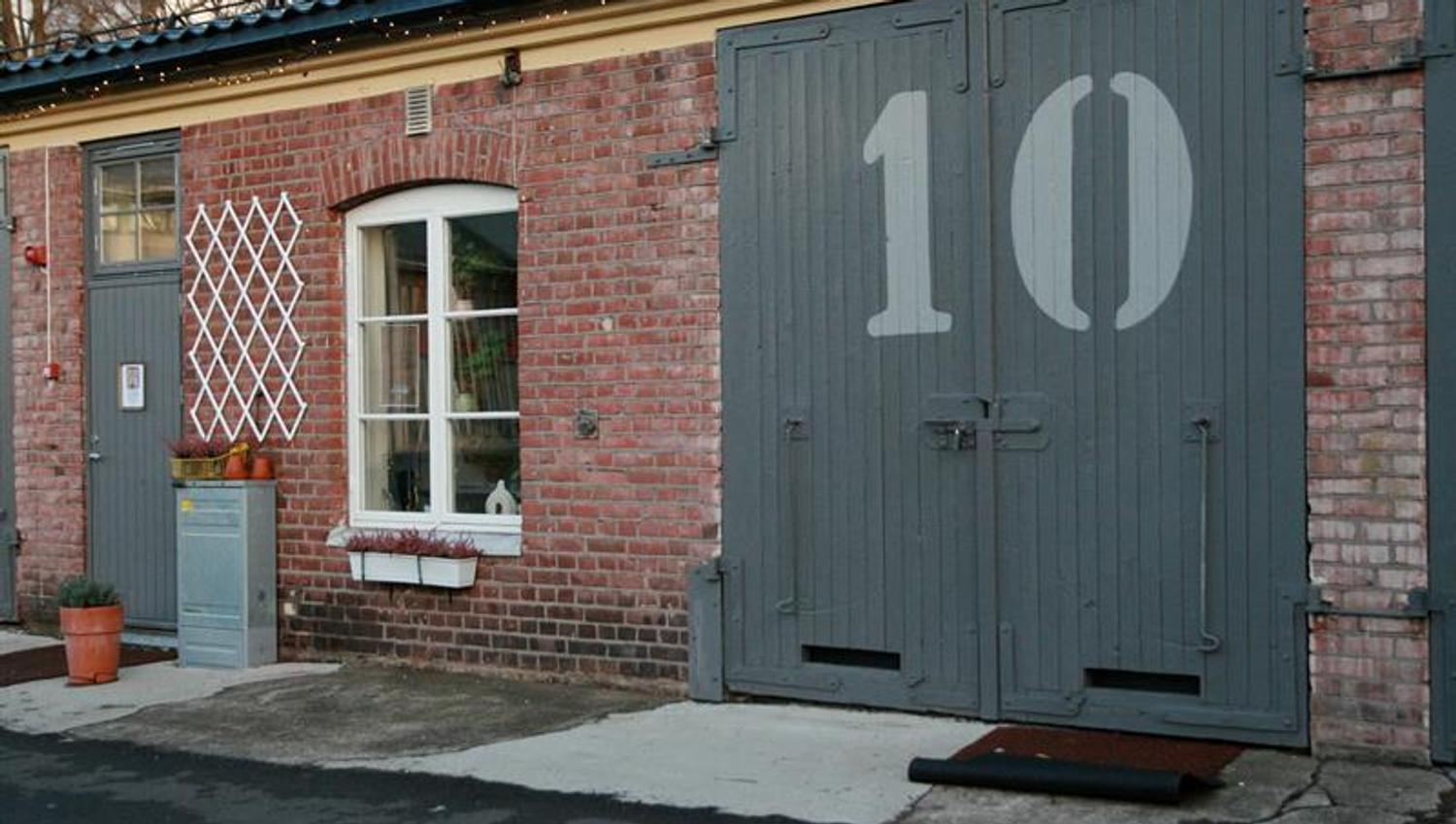 Mursteinsfasade med store grå dører merket «10» ved Nummer Ti på Karljohansvern i Horten.