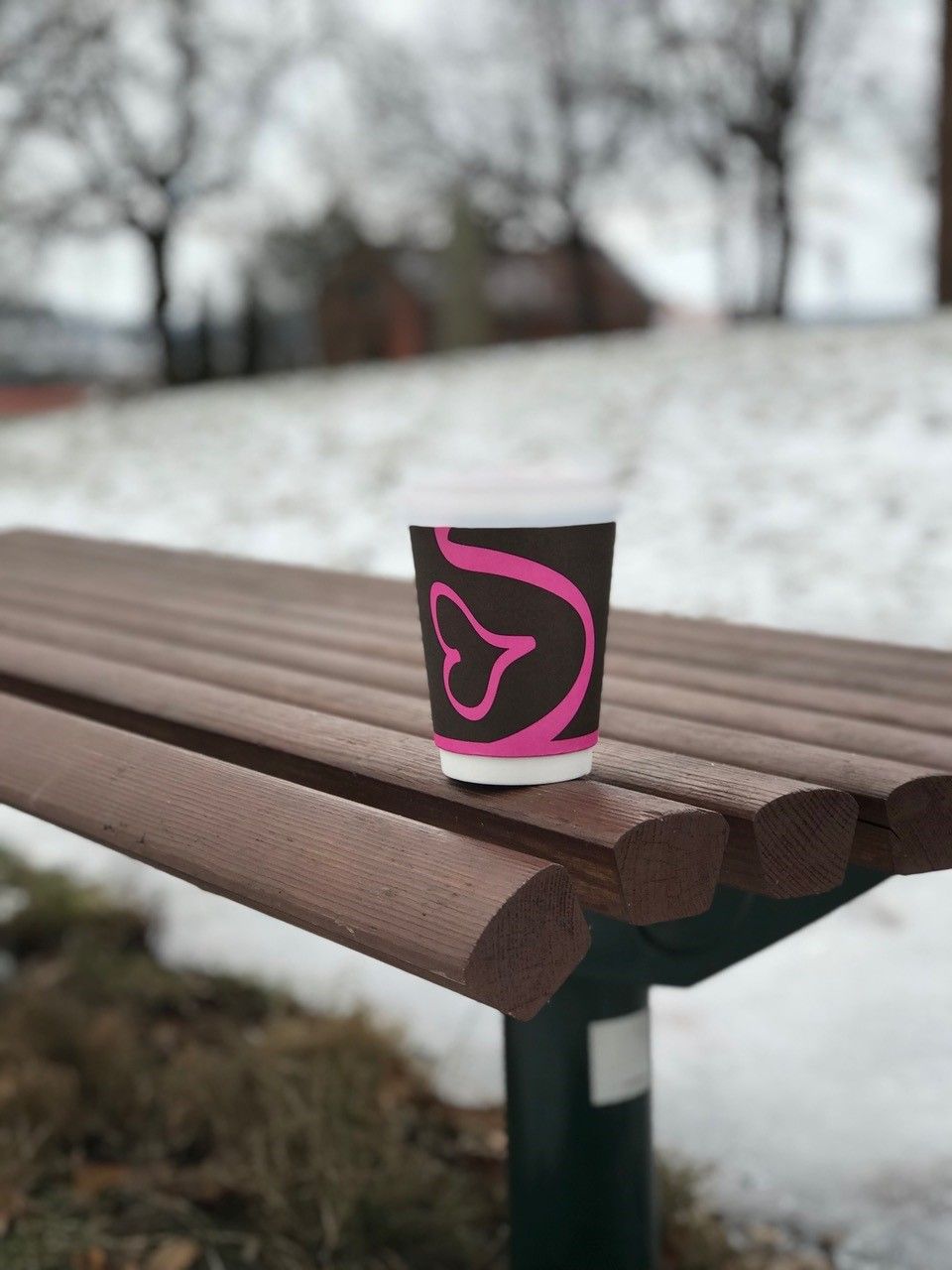 Cup with coffee outside on a bench in winter