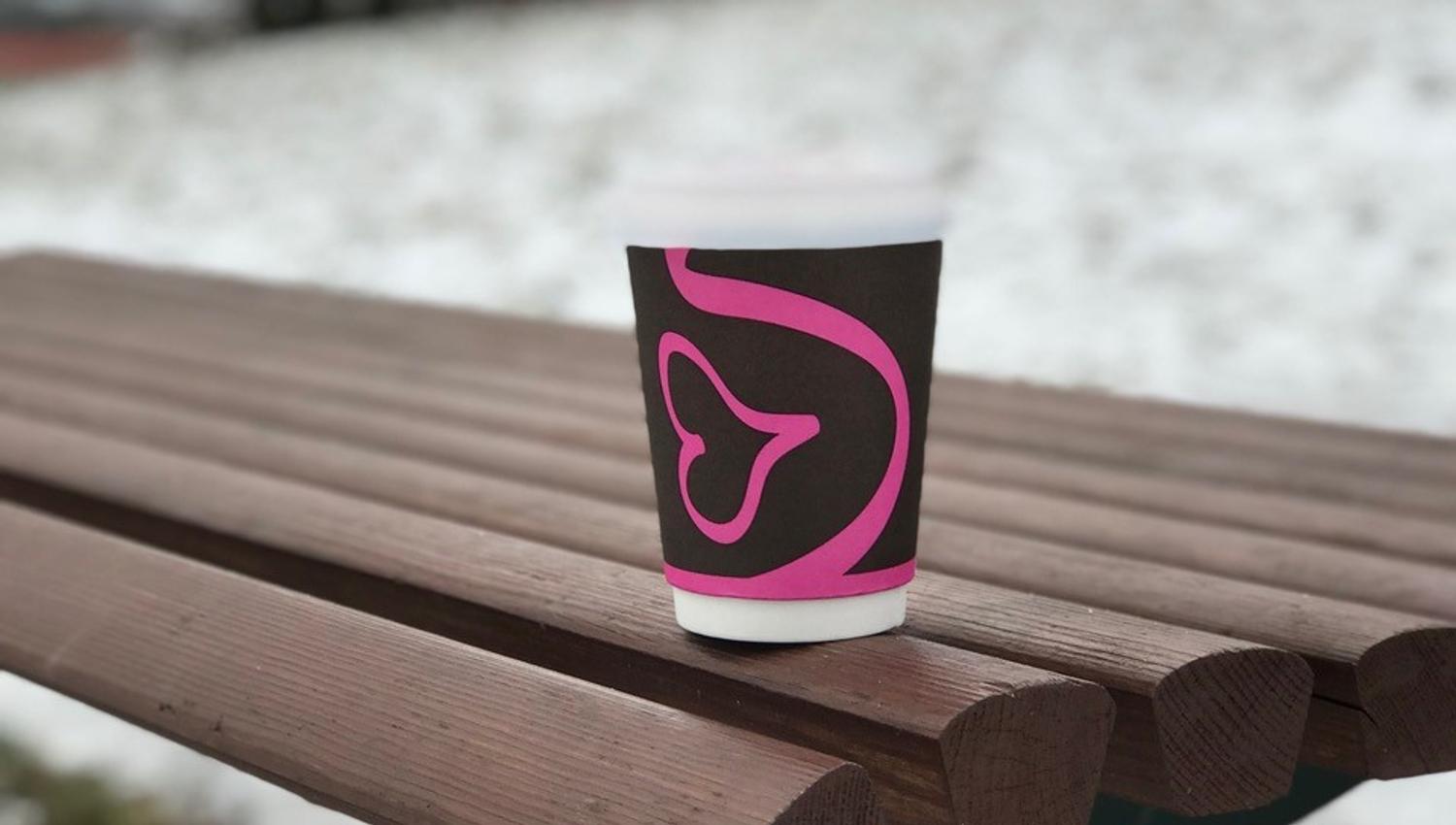 Cup with coffee outside on a bench in winter