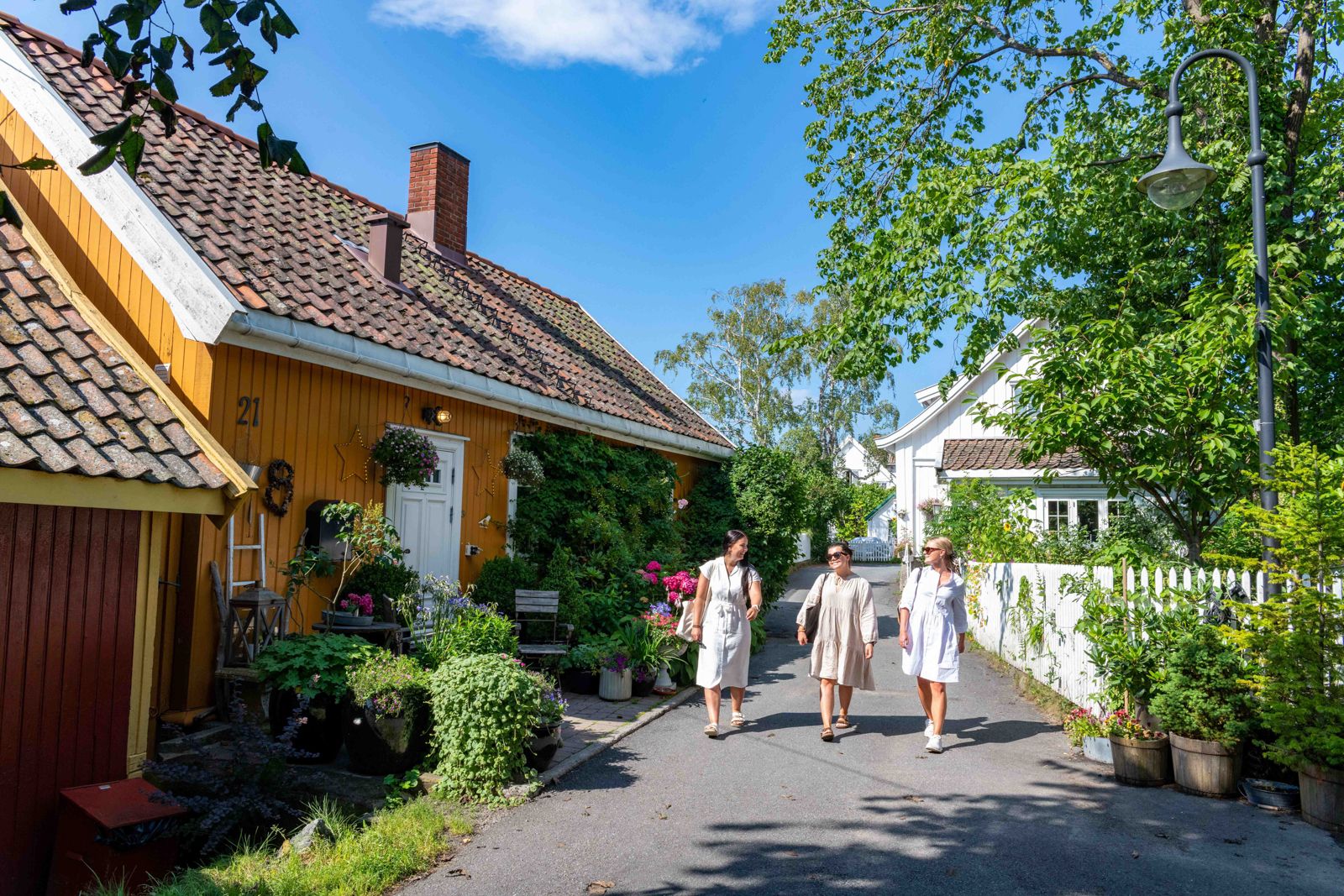 The Badehus road in Drøbak, yellow house and tree women walking
