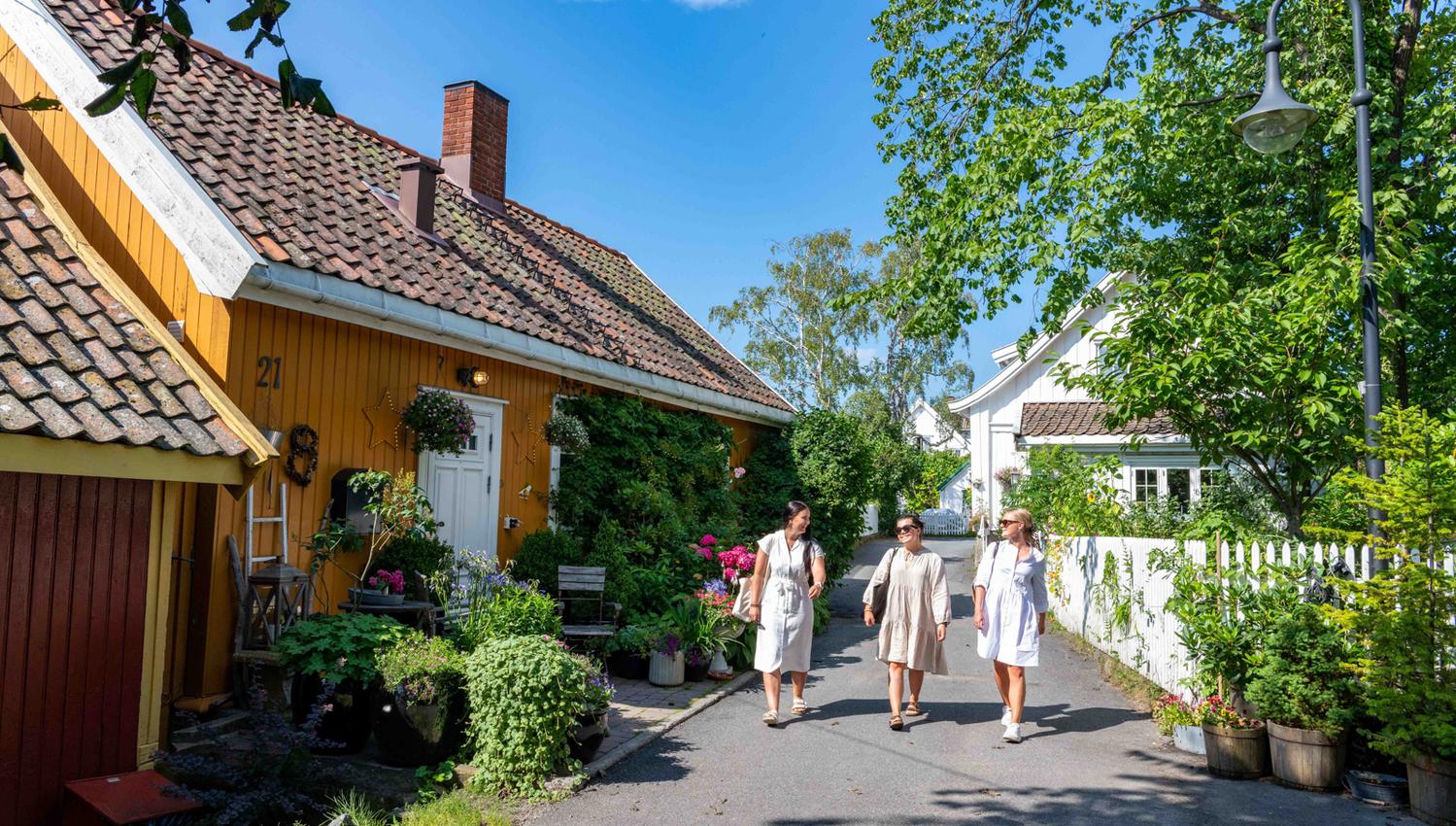 The Badehus road in Drøbak, yellow house and tree women walking