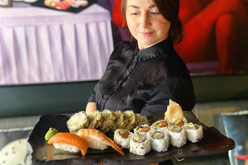 Waitress carrying a sushi plate.
