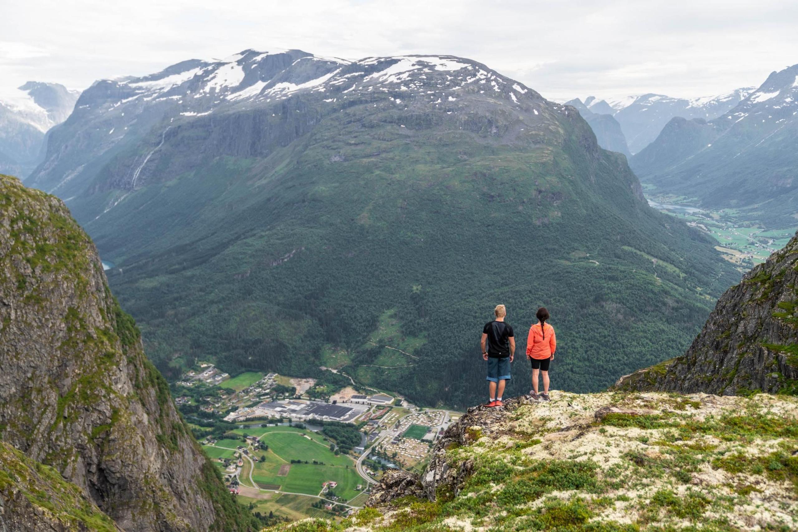 Two hikers taking a break on the mountain above Loen, overlooking the fjord and mountains.