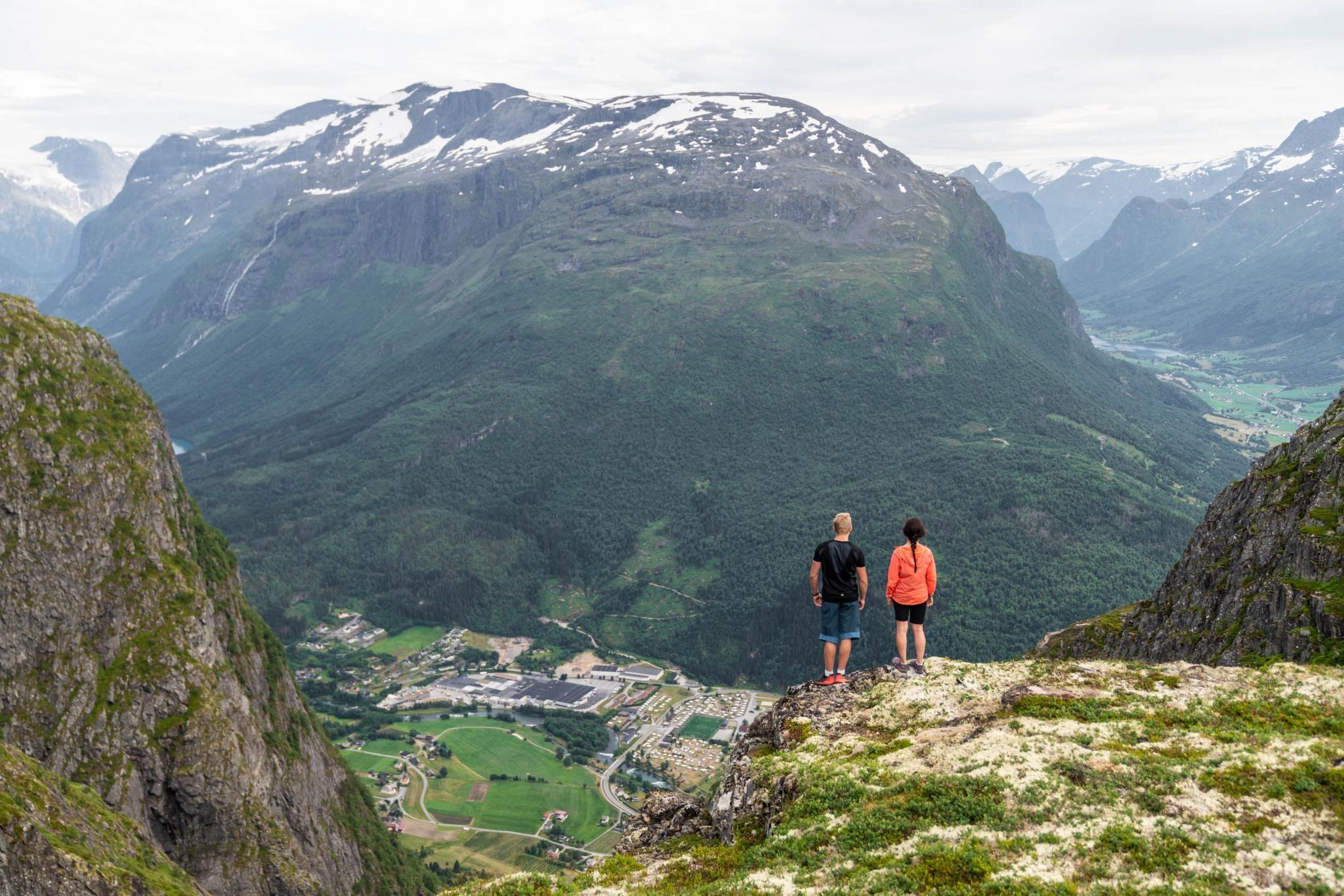 Two hikers taking a break on the mountain above Loen, overlooking the fjord and mountains.