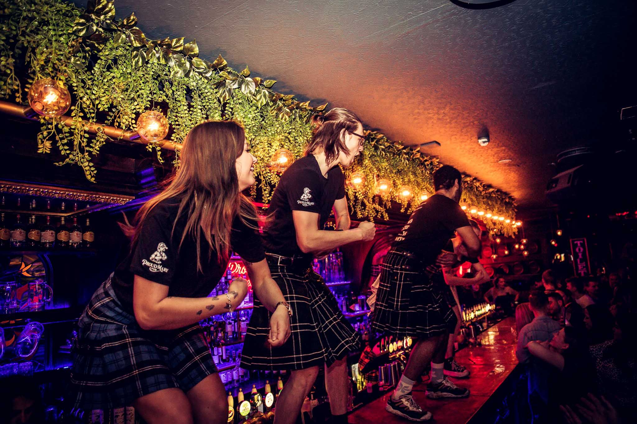 Waiters dancing on the bar counter