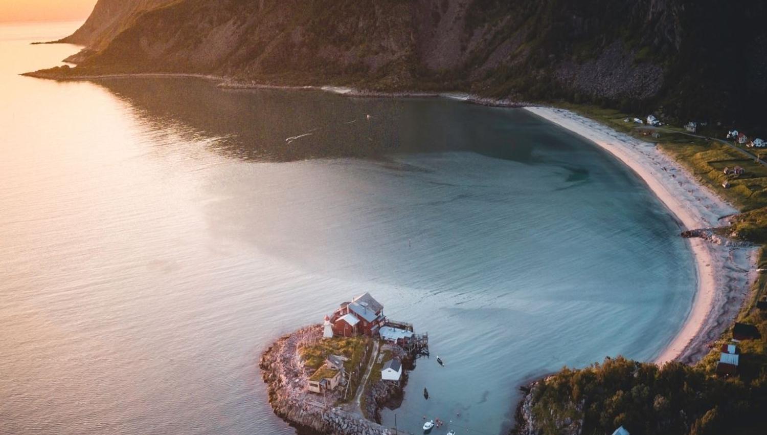 The view over the sea, the beach and a small island with a house on it