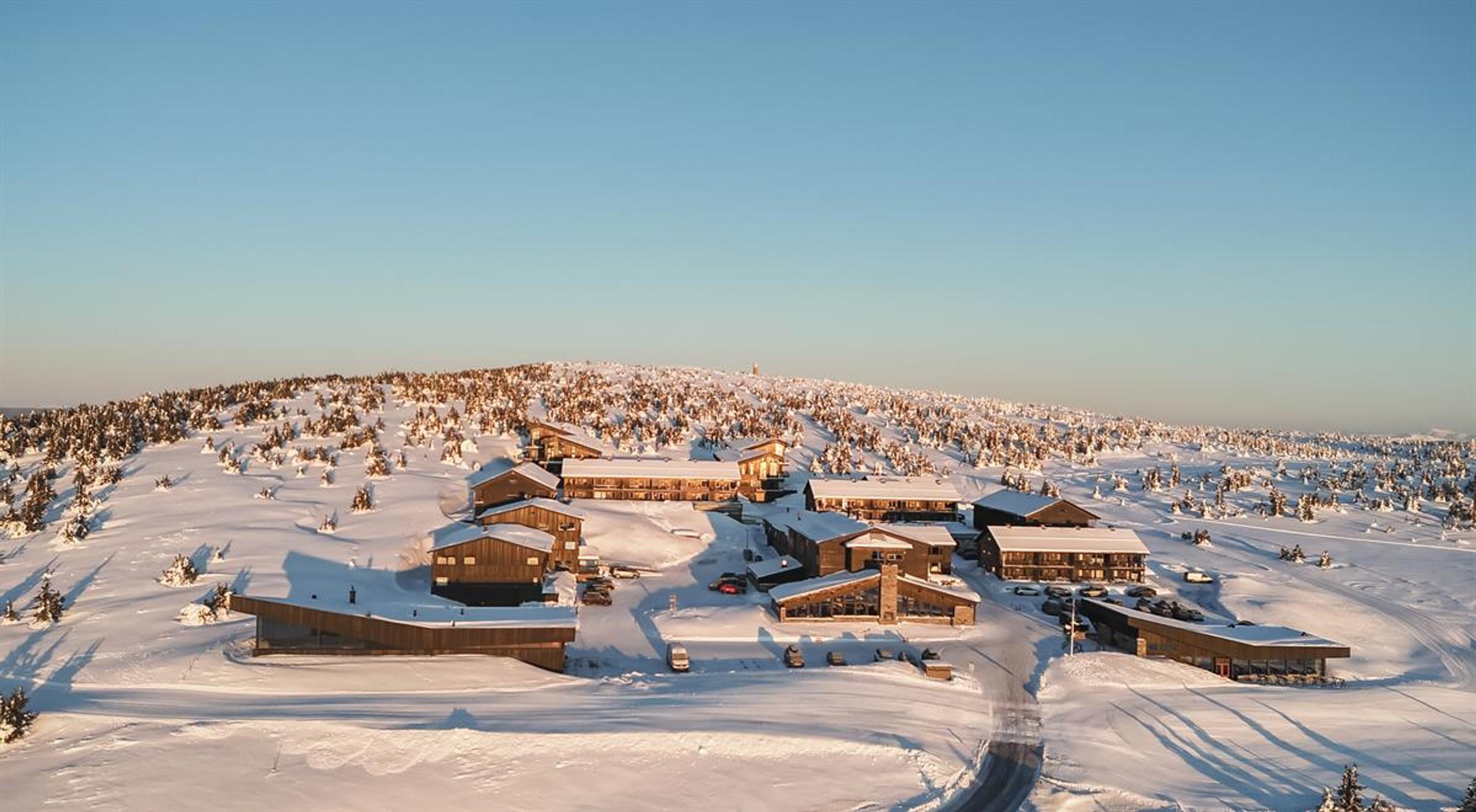 Winter view of Pellestova surrounded by snow-covered mountain landscape.