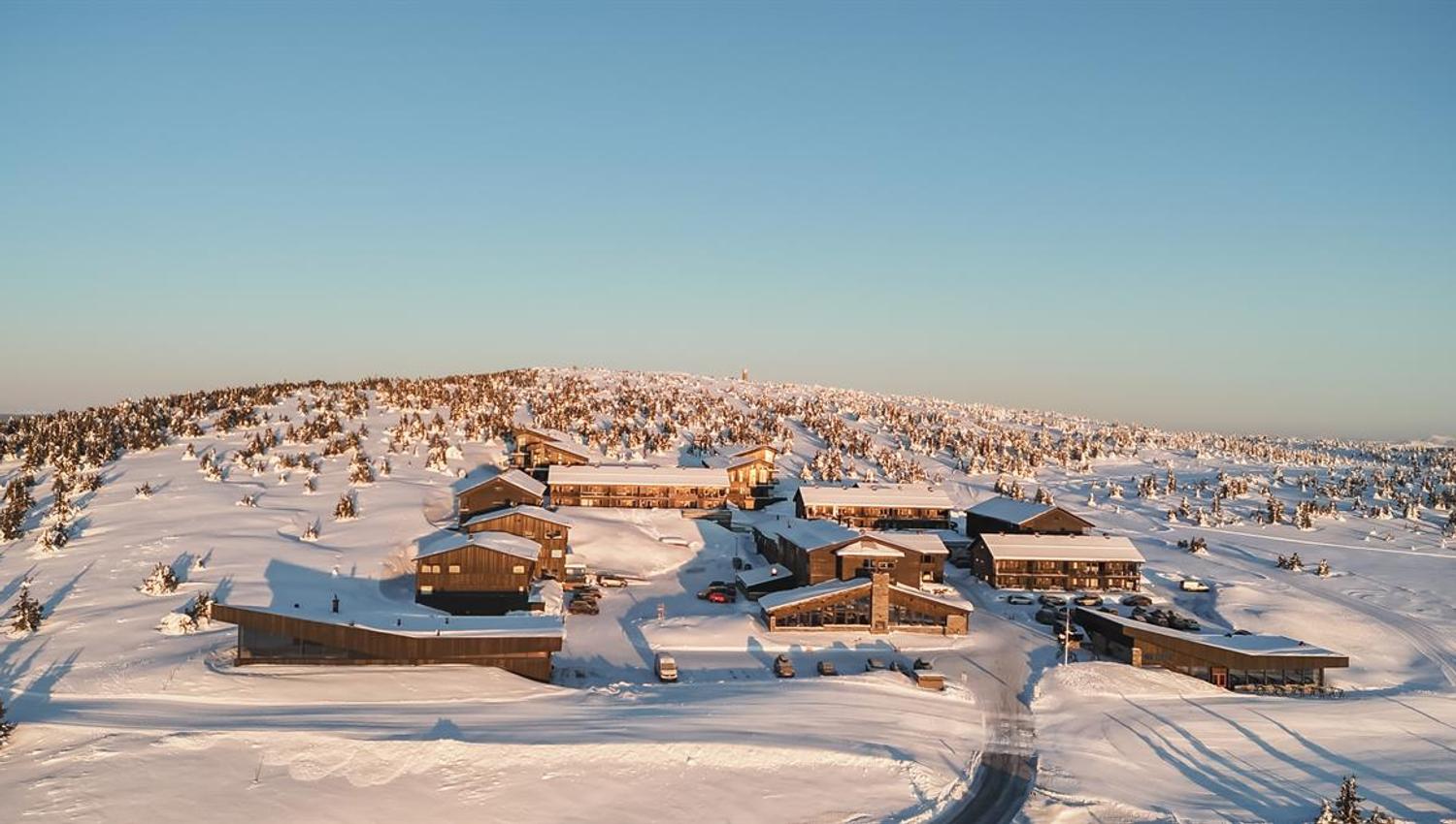 Winter view of Pellestova surrounded by snow-covered mountain landscape.