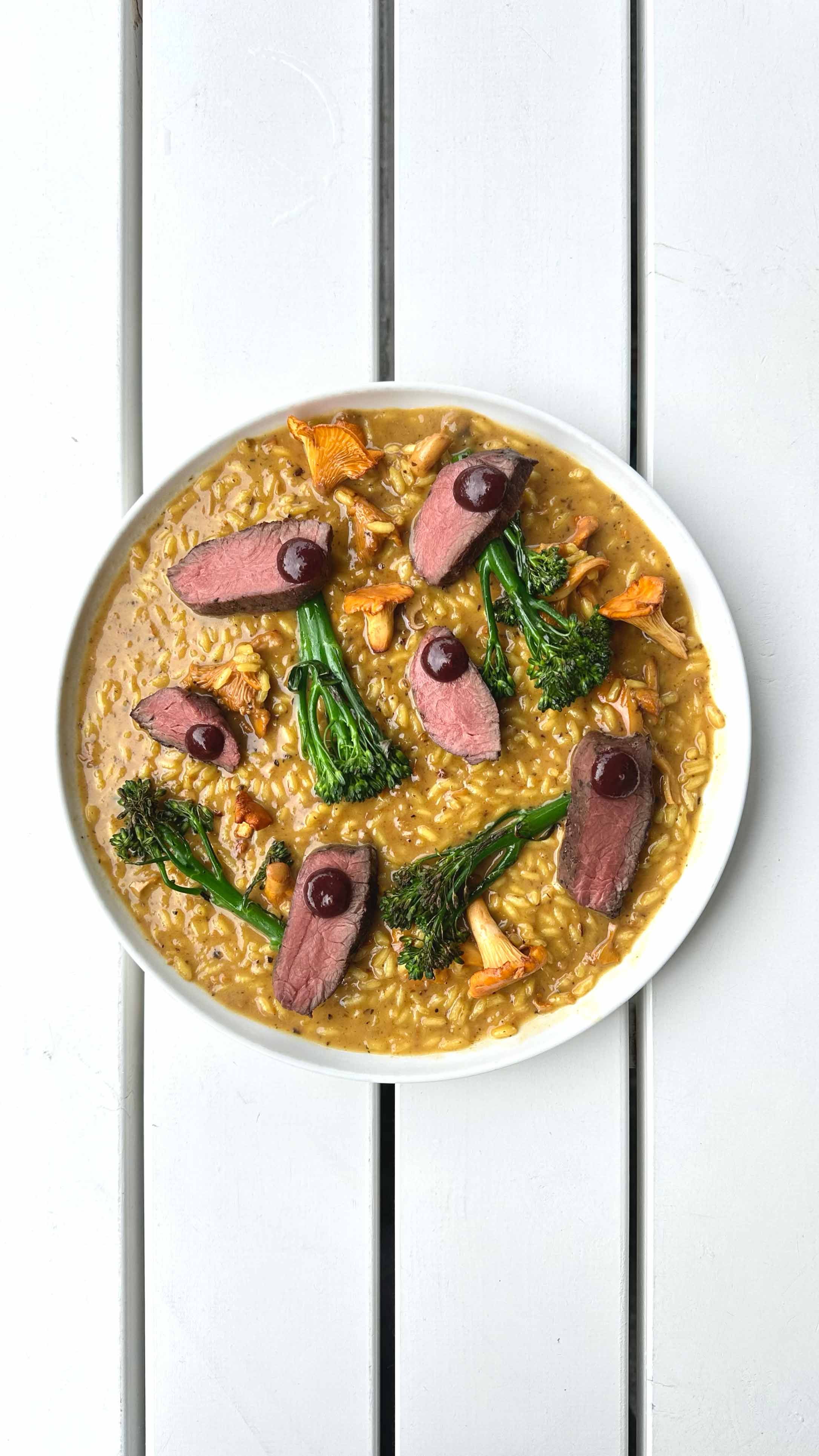 A gourmet risotto dish at Vik Restaurant, Bakeri & Kafé, served with broccolini and chanterelles.