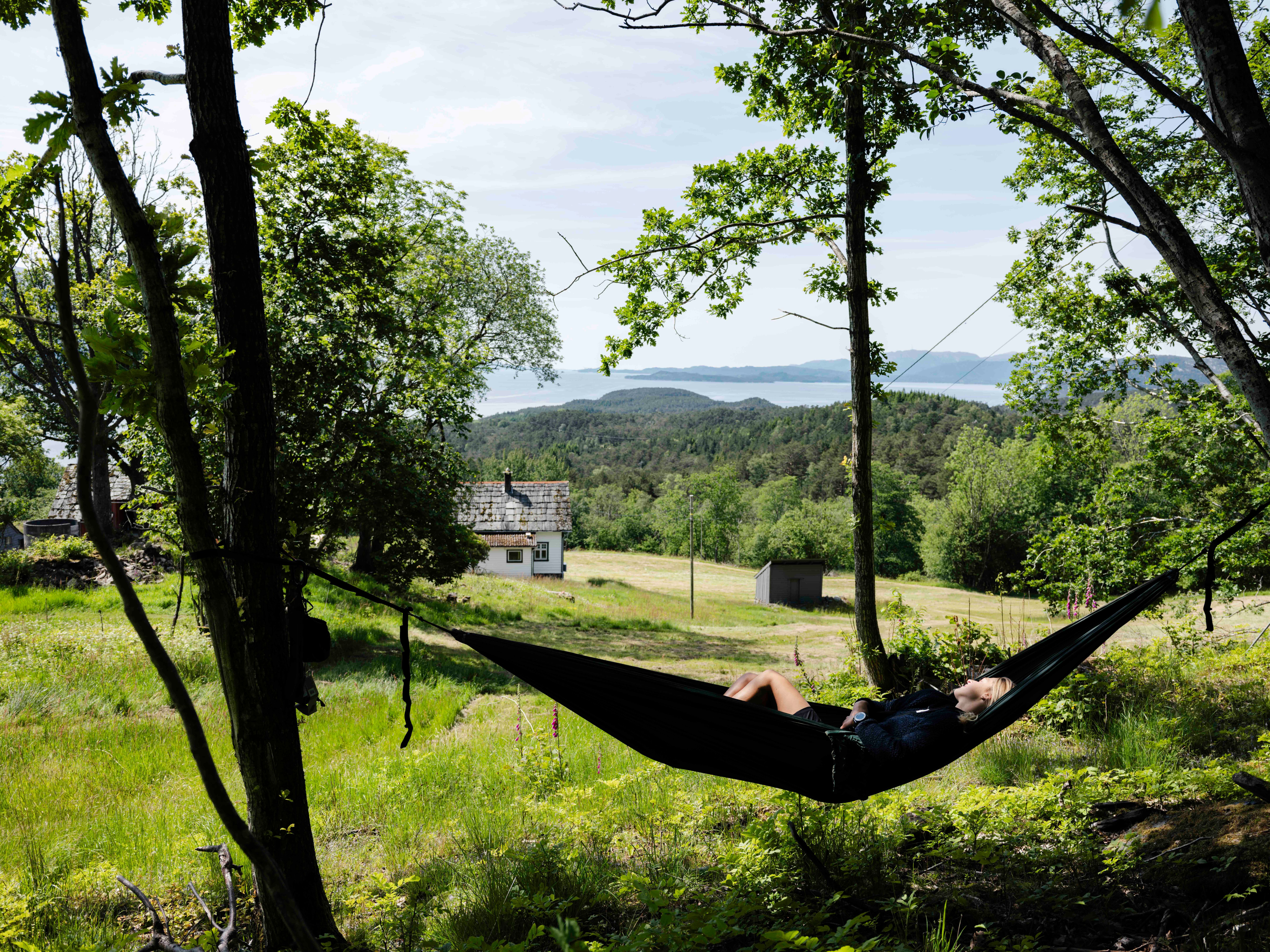 Relaxing in a hammock with views of the Hardangerfjord at Stigen Fjordlodge.