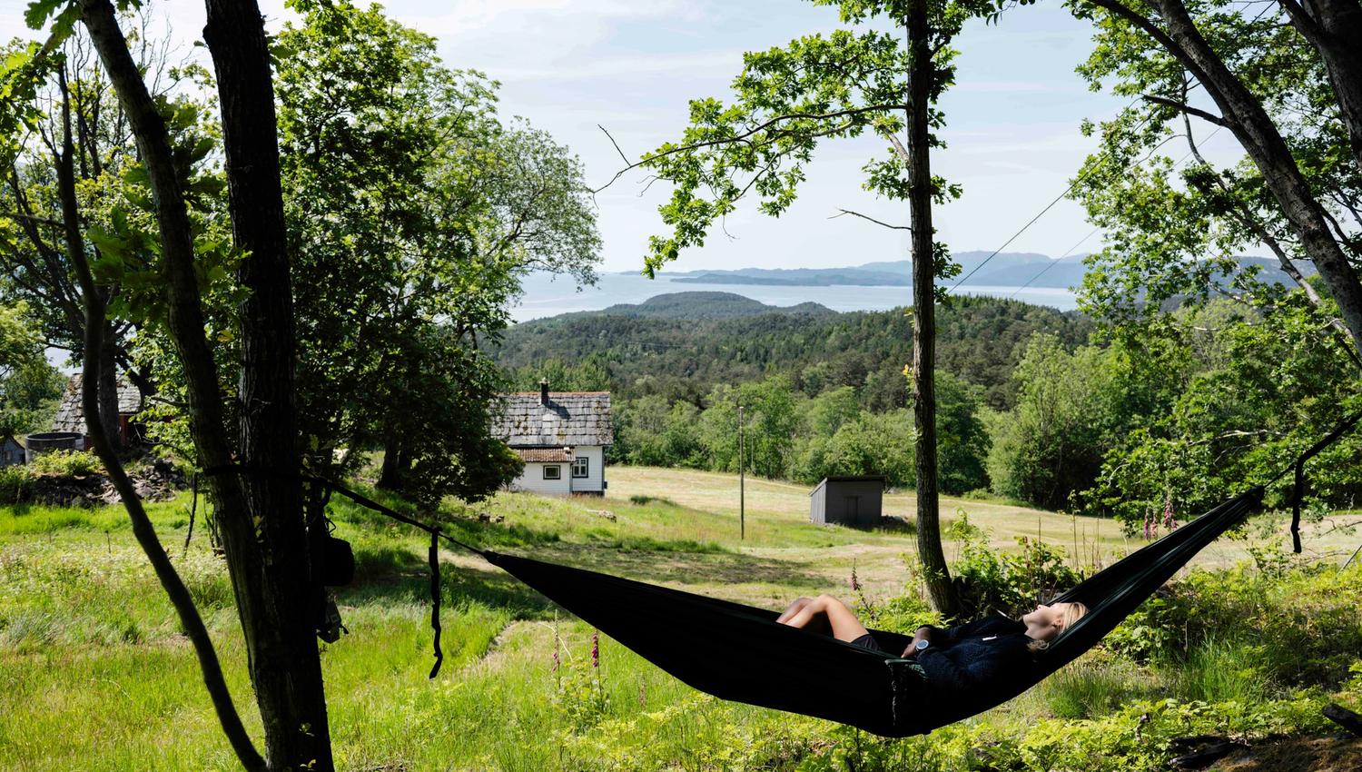 Relaxing in a hammock with views of the Hardangerfjord at Stigen Fjordlodge.