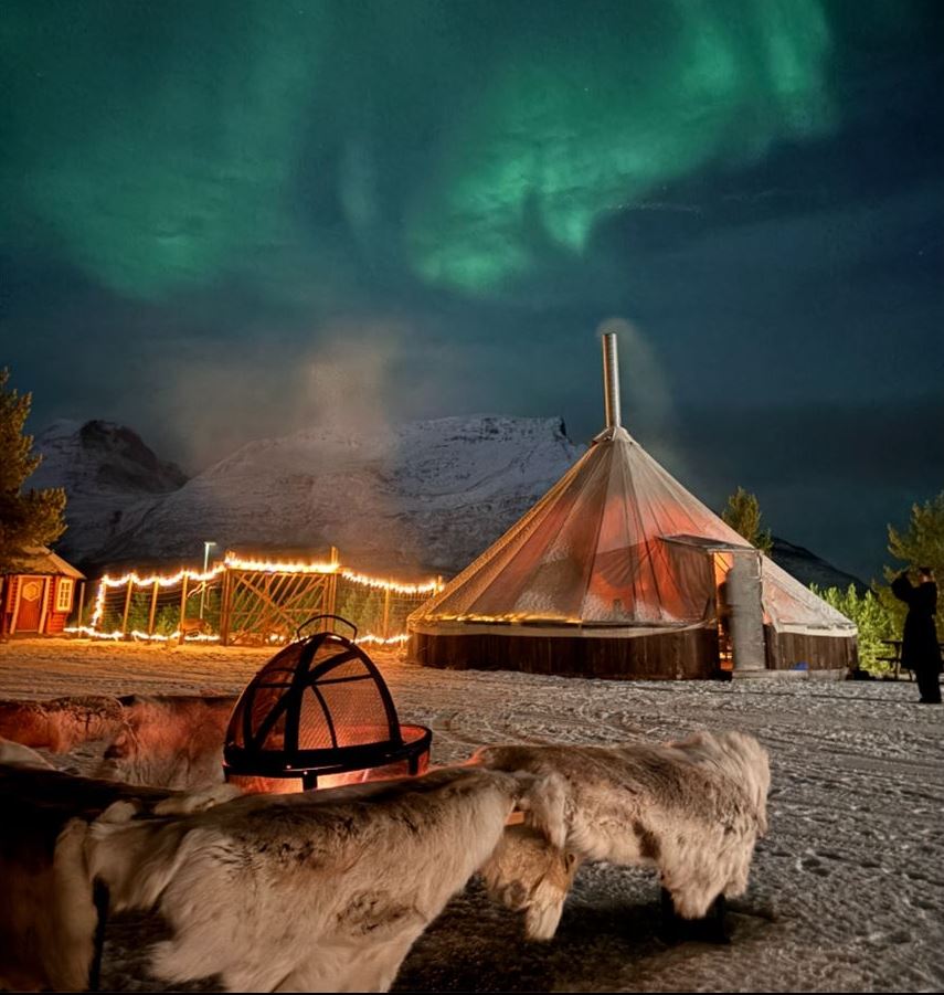 Fire pit and a traditional lavvu under the Northern Lights in Skibotn