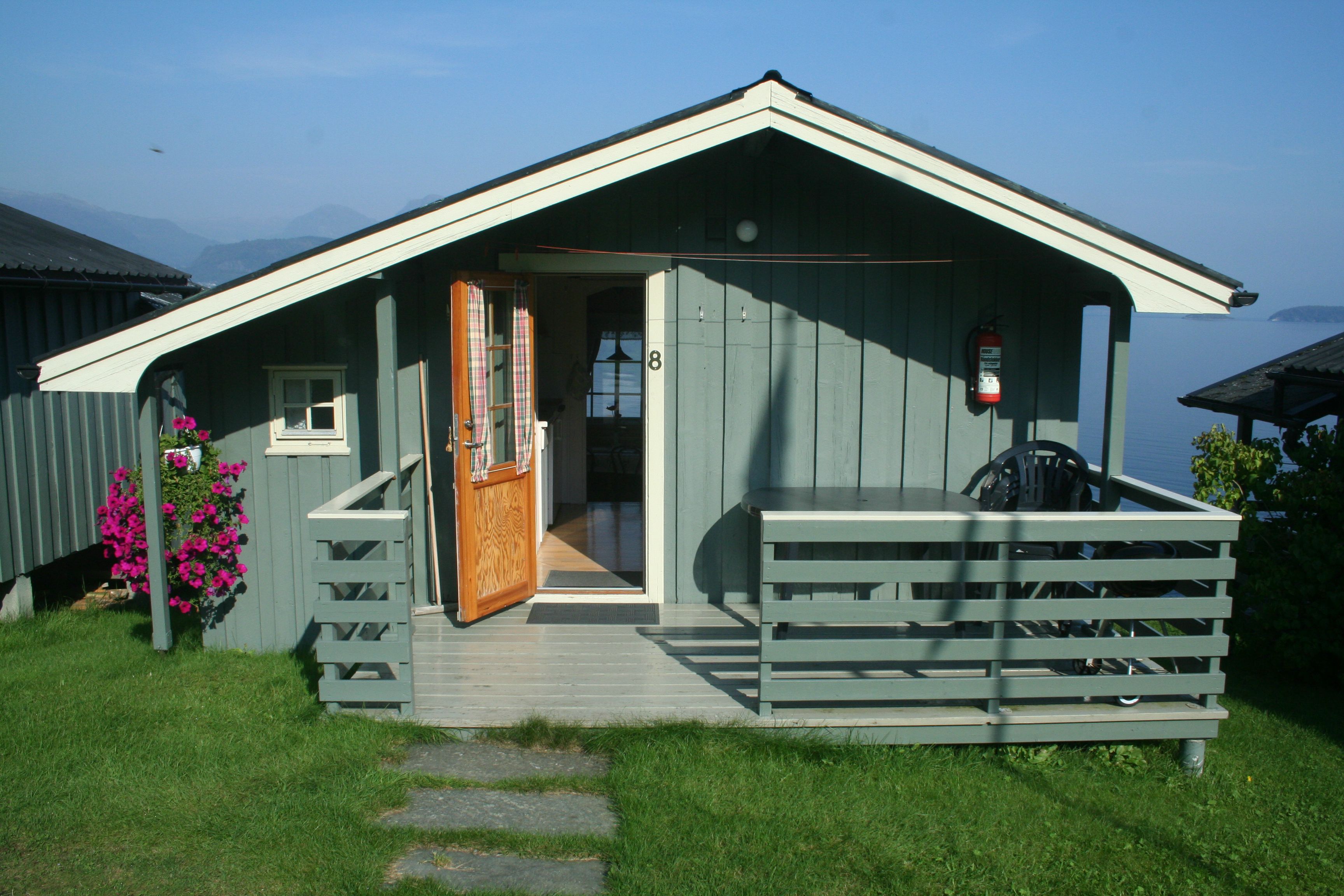 Open cabin at Oddland Camping showing the living area and view of the Hardangerfjord.