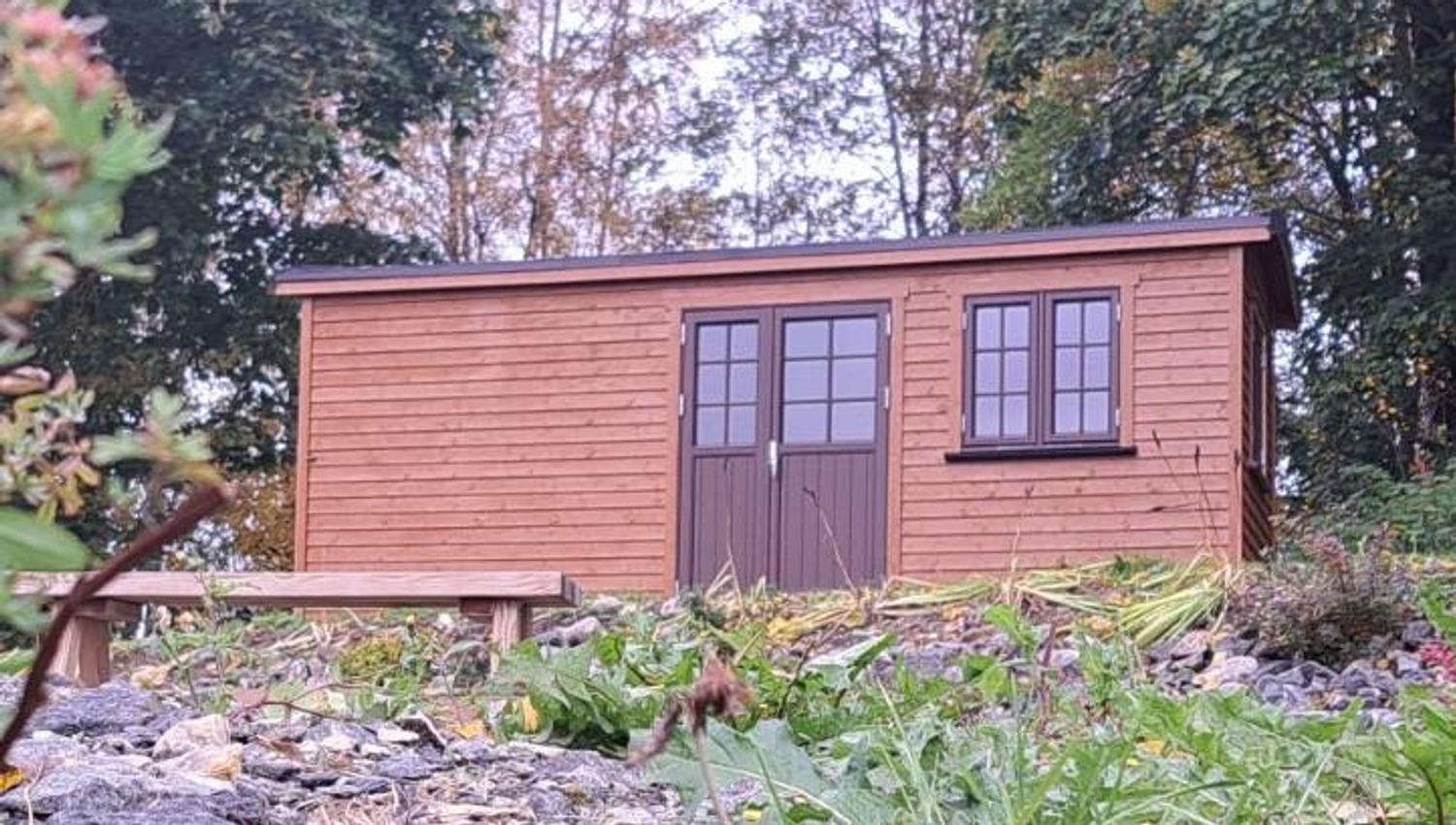 Exterior view of Gjeterhytta – small newly built wooden cabin with door and windows