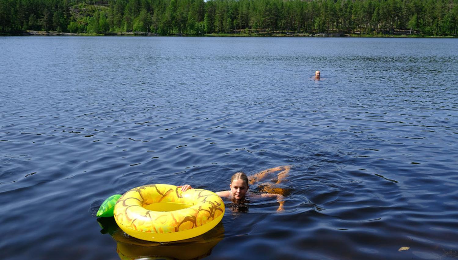 Jente som bader i Tinnemyra med gul badering i Notodden. Foto