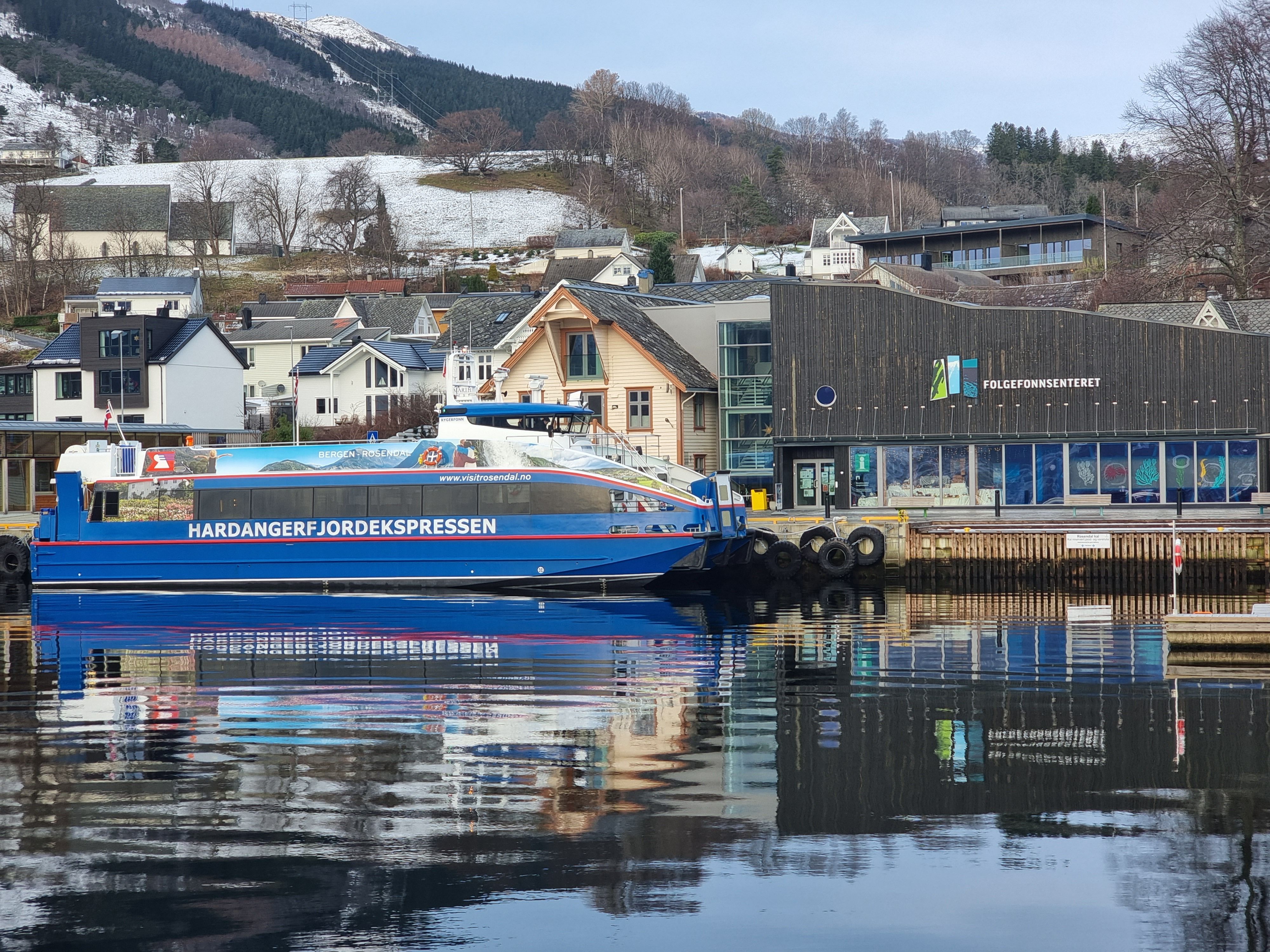 Hardangerfjordekspressen docked at a charming fjord town in Hardanger.