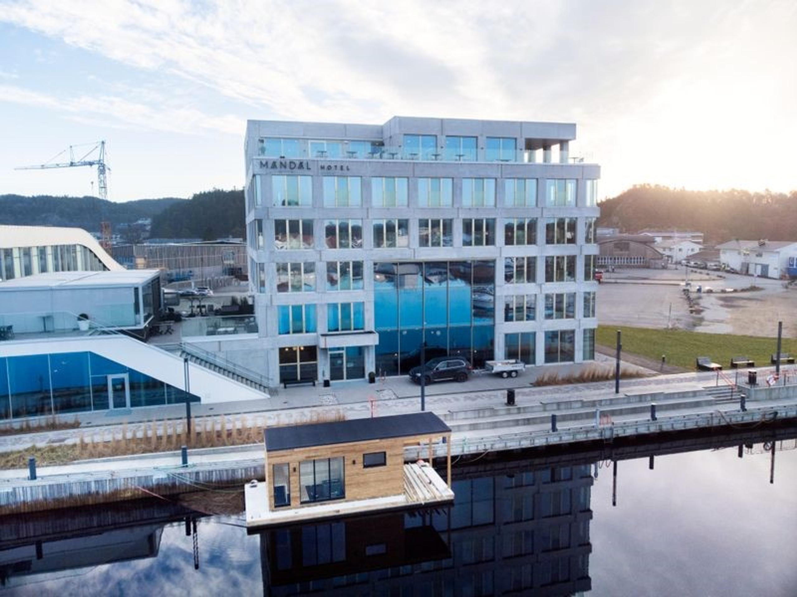 Oversiktsbilde av Mandal Hotel og badstubåten Pysen som ligger i Mandalselva