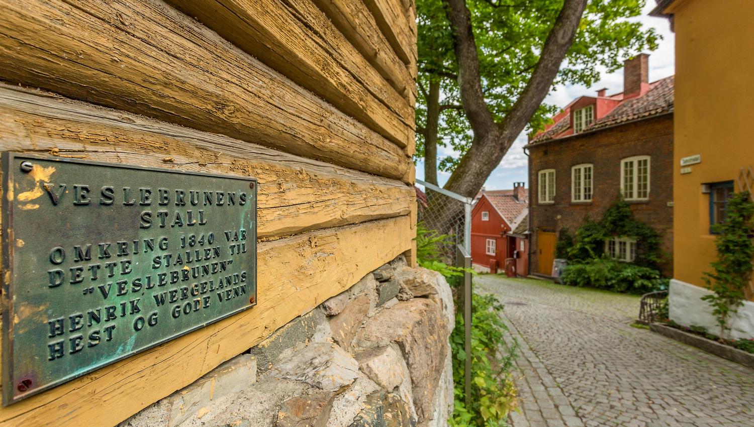 A plaque on an old, yellow wooden house.