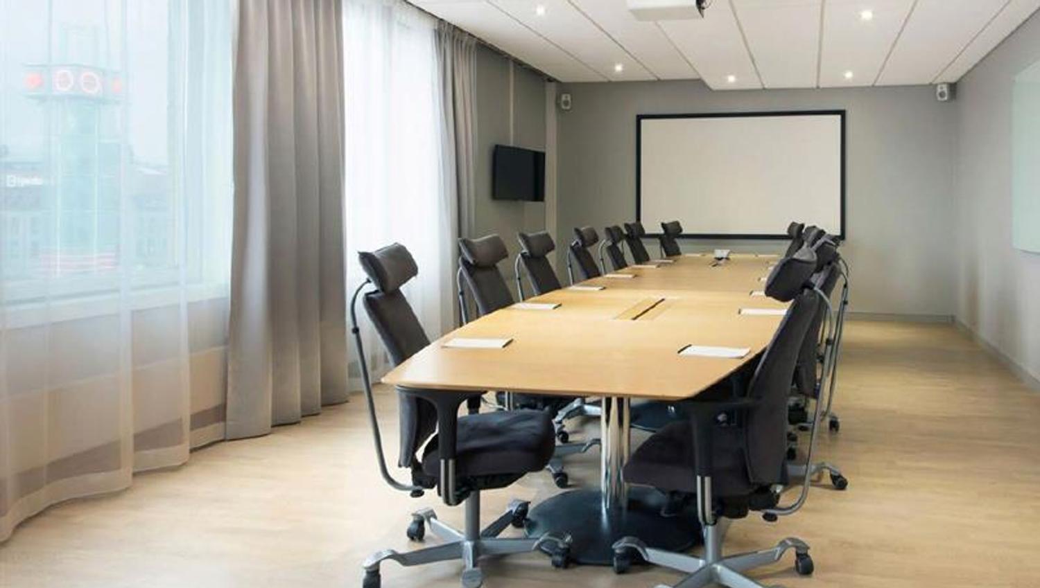 conference room with a large conference table and projector with screen