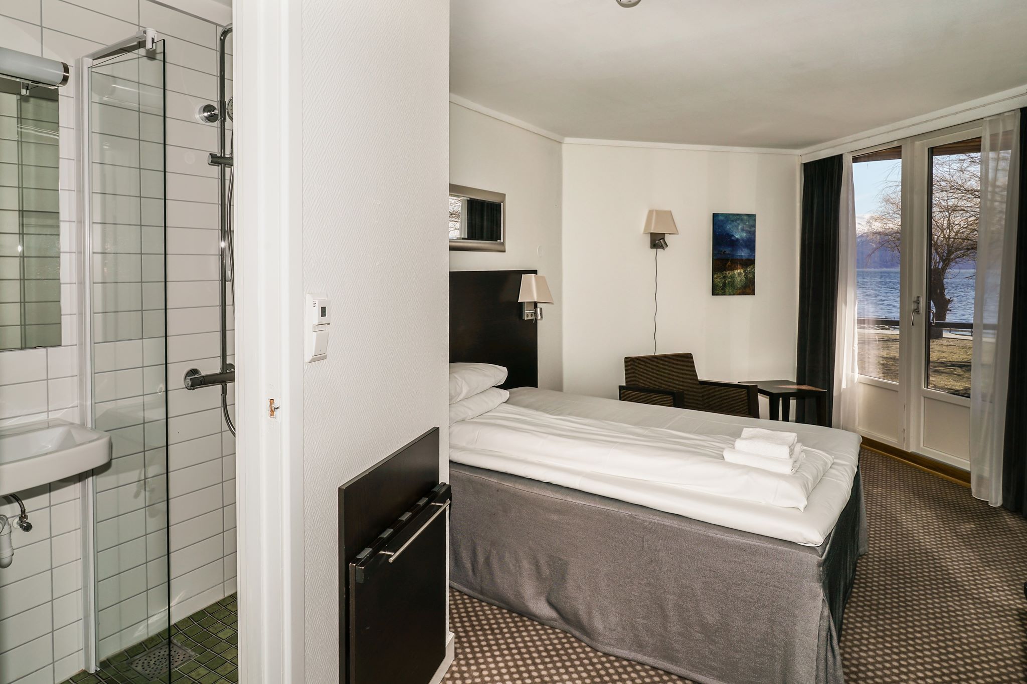 Hotel room with a single bed and a beautiful view of the fjord from the window.