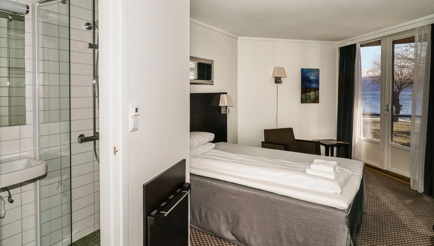 Hotel room with a single bed and a beautiful view of the fjord from the window.