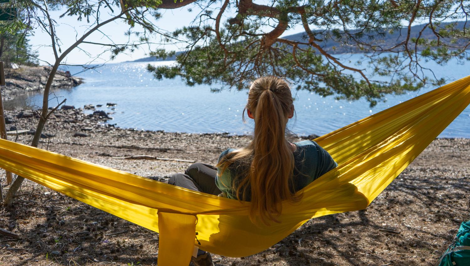Dame som slapper av i hengekøye i Kjeppestadbukta