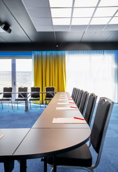 Interior of conference room with chairs, table and large panoramic windows.