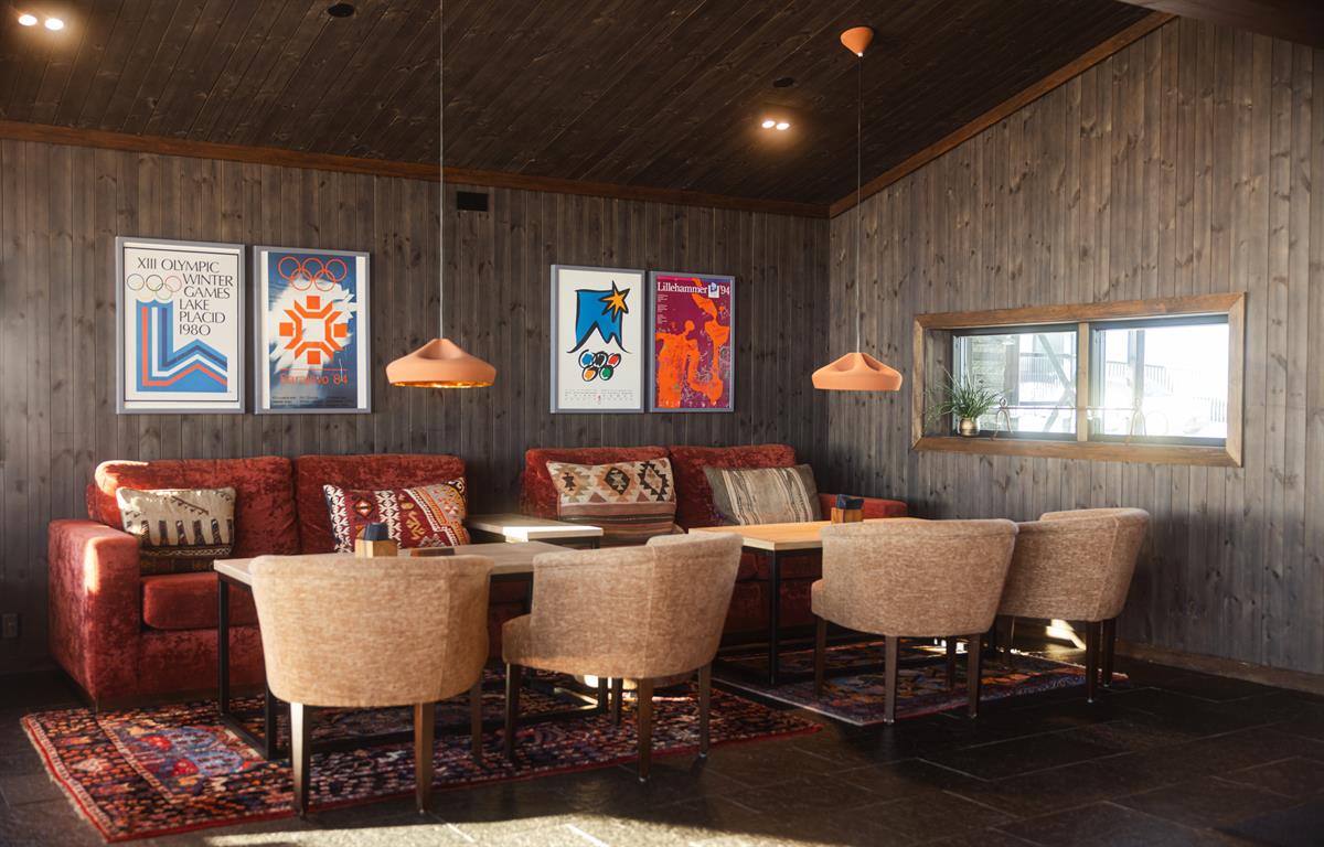 Restaurant interior with fireplace, artwork and seating areas.