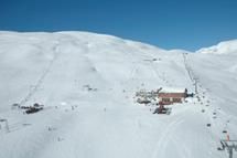 Hauptgebäude und Skilifte im Røldal Skigebiet, umgeben von schneebedeckten Bergen.
