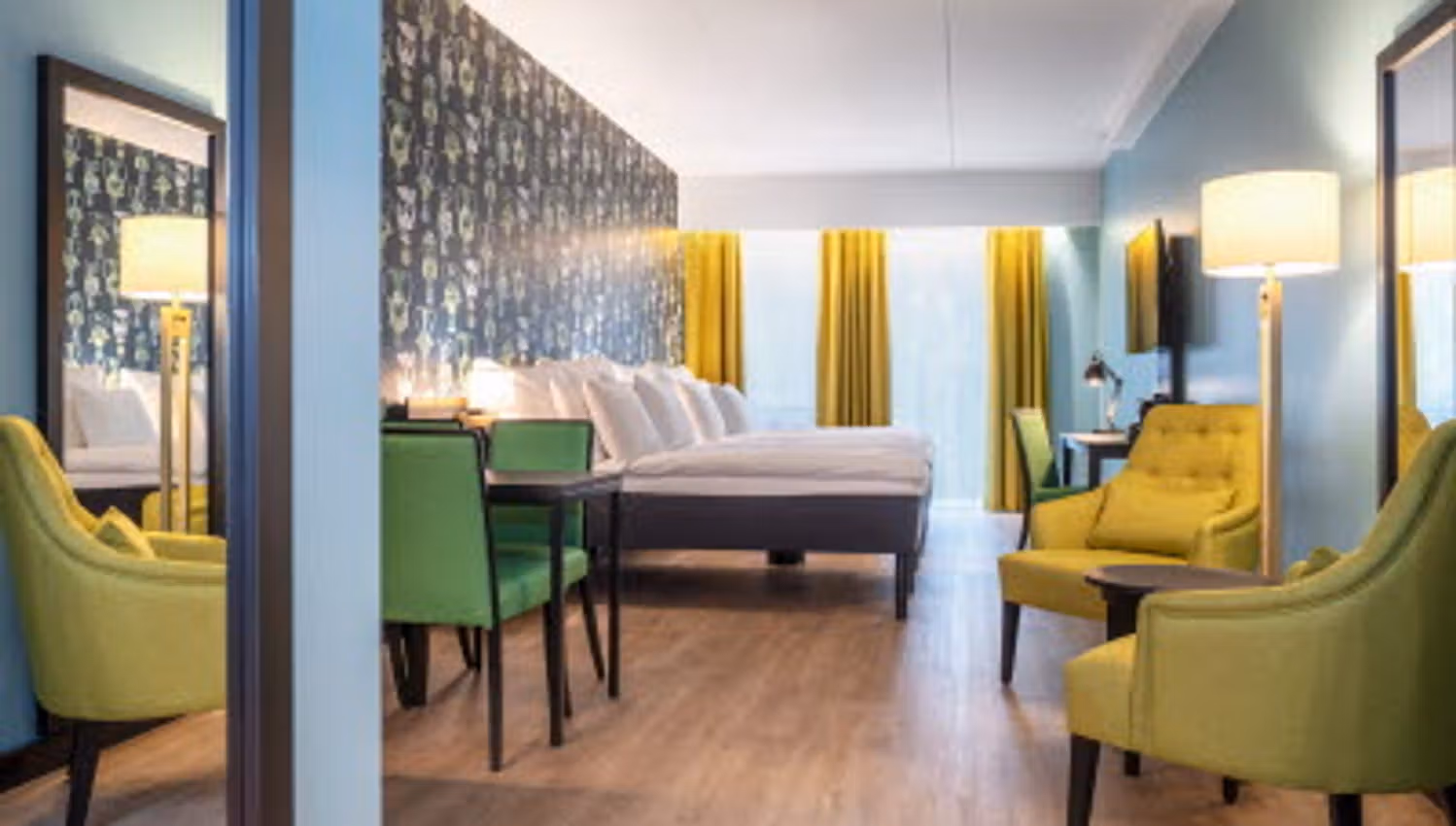 Room interior with double bed, yellow armchairs, table and yellow curtains.