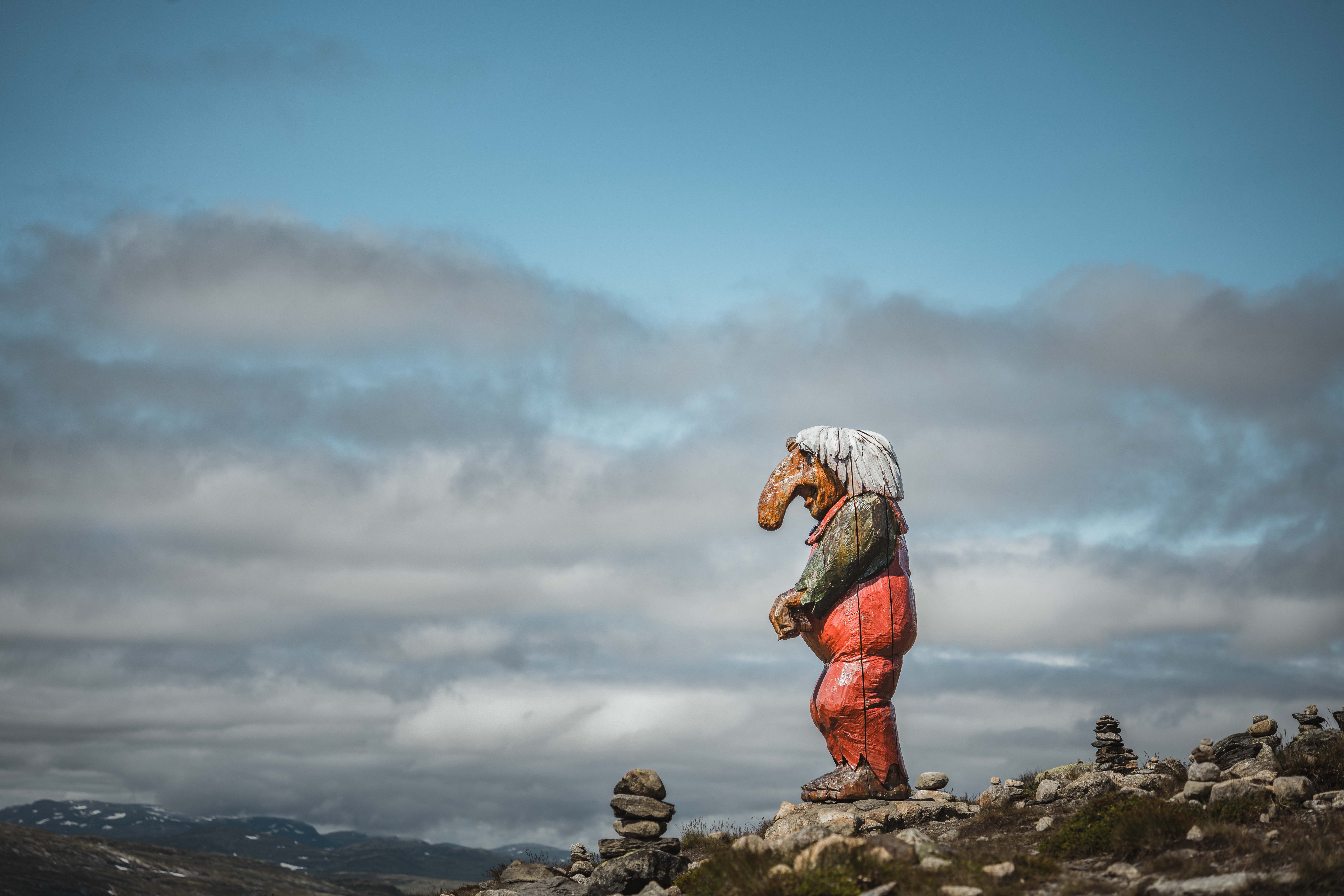 A big wooden troll on top of a hill, gazing towards Dyranut.