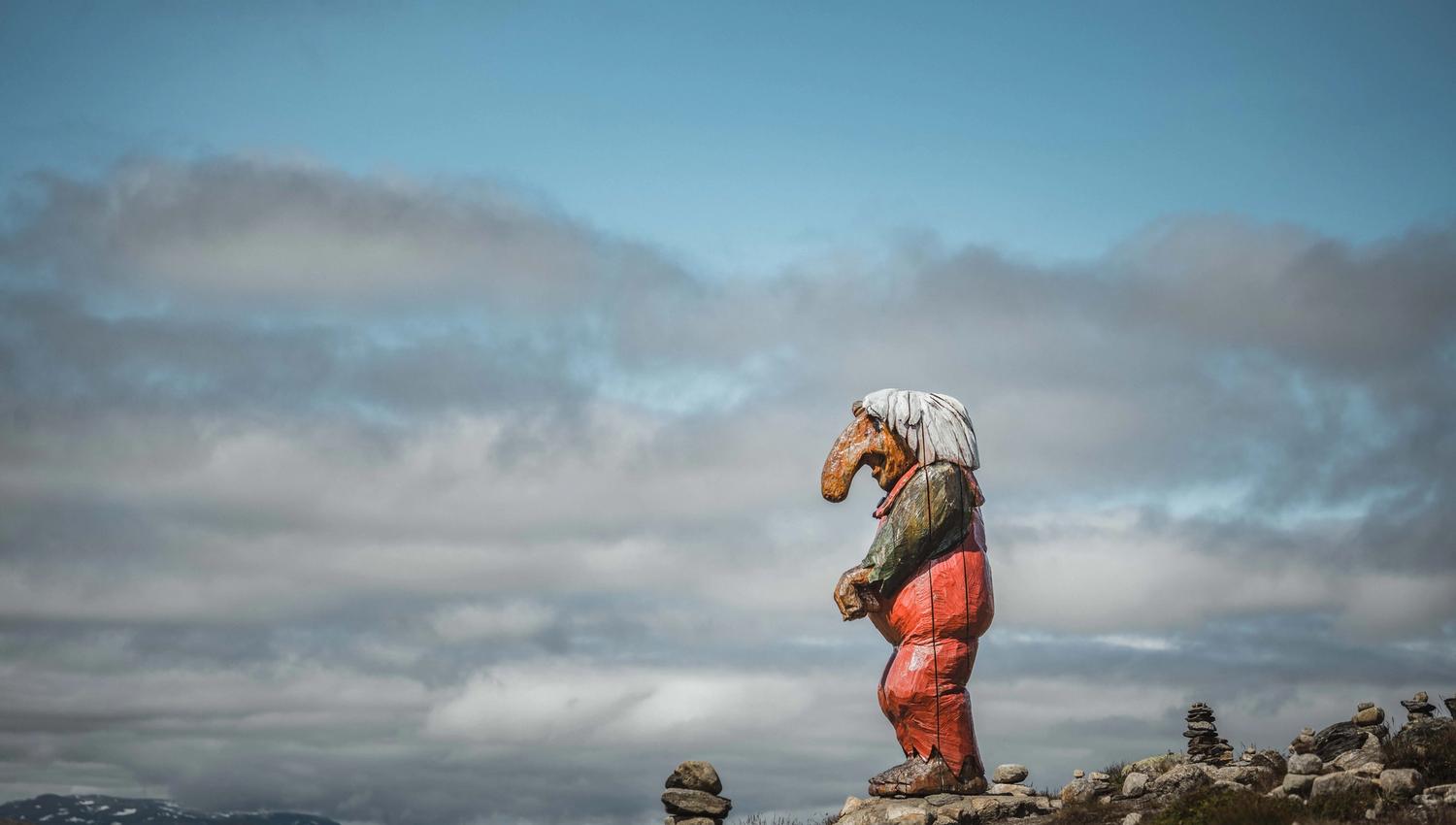 A big wooden troll on top of a hill, gazing towards Dyranut.