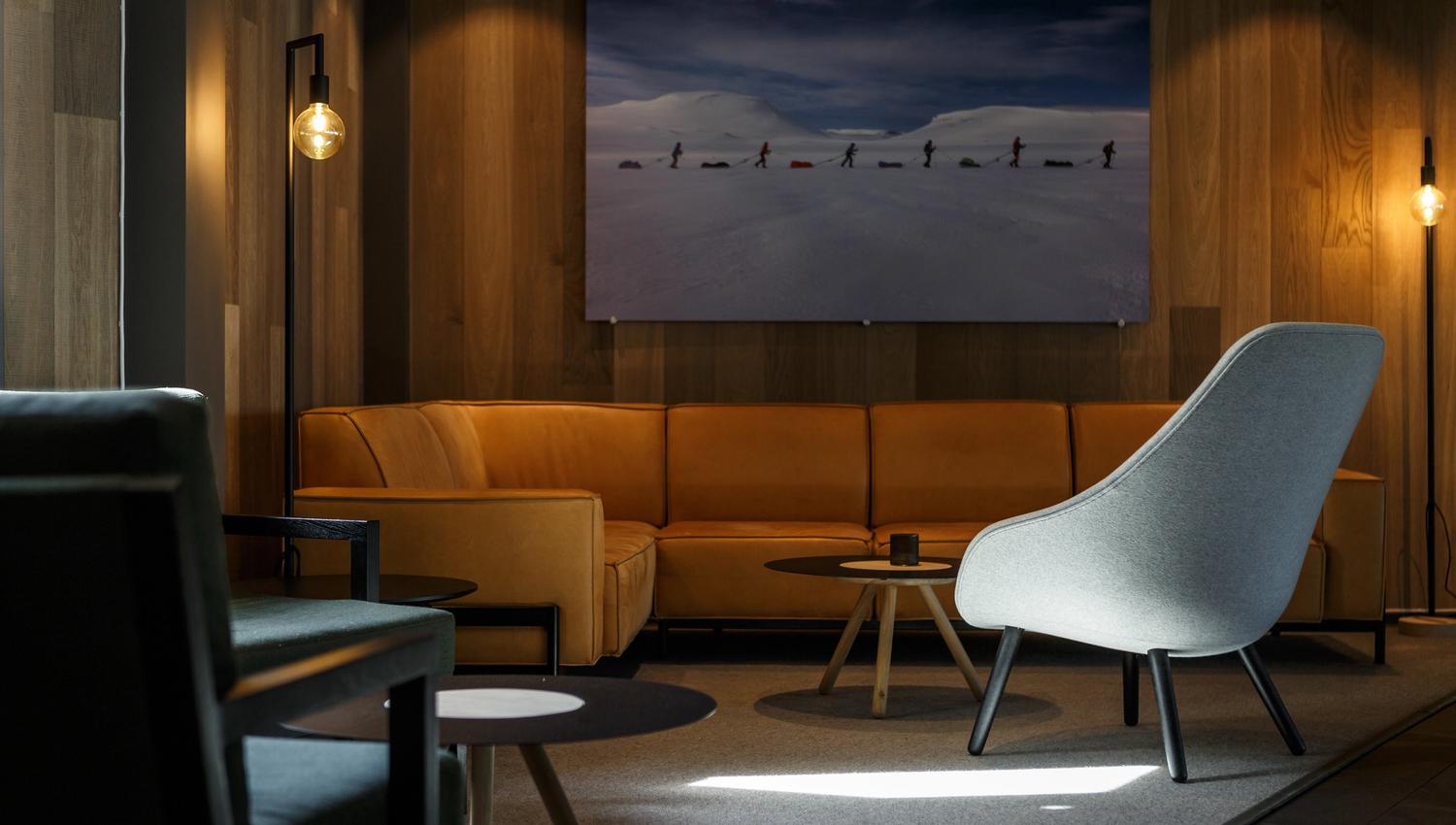 A lounge area with a large photo of people skiing in the background.