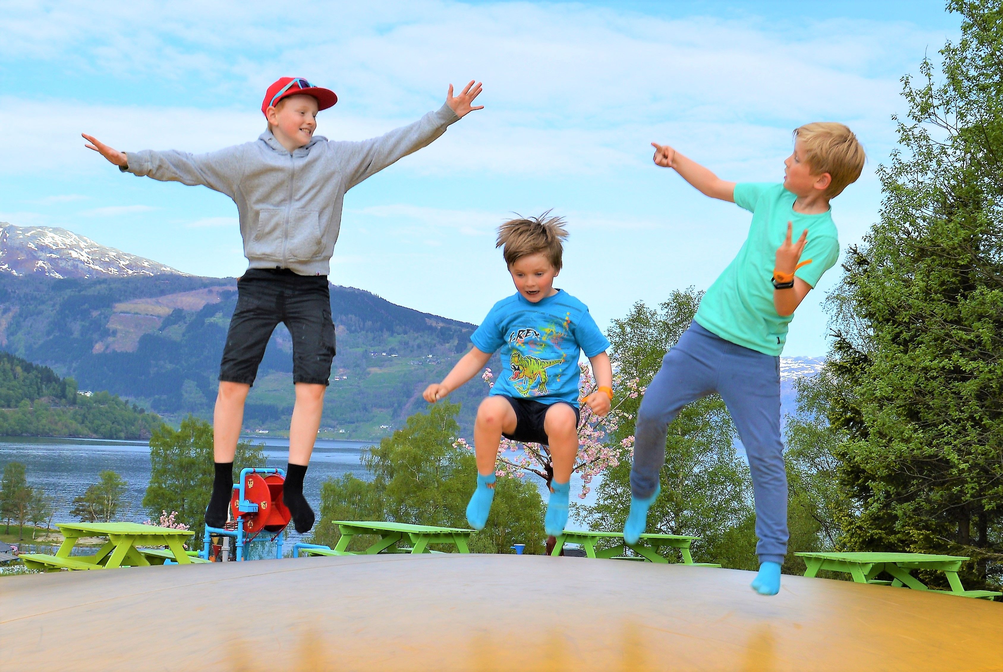 Born hoppar og kosar seg på trampolinen med fjordutsikt i Mikkelparken