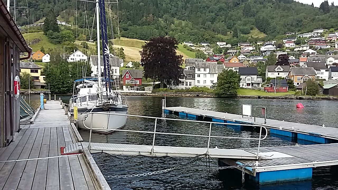 Dock and berthing area at Norheimsund Guest Harbour, with views towards the town and surrounding mountainsides.