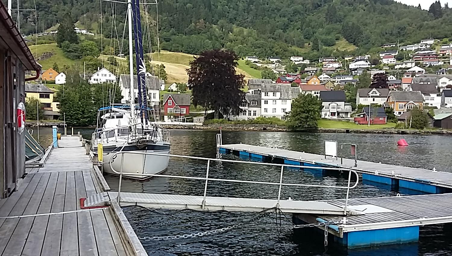 Dock and berthing area at Norheimsund Guest Harbour, with views towards the town and surrounding mountainsides.