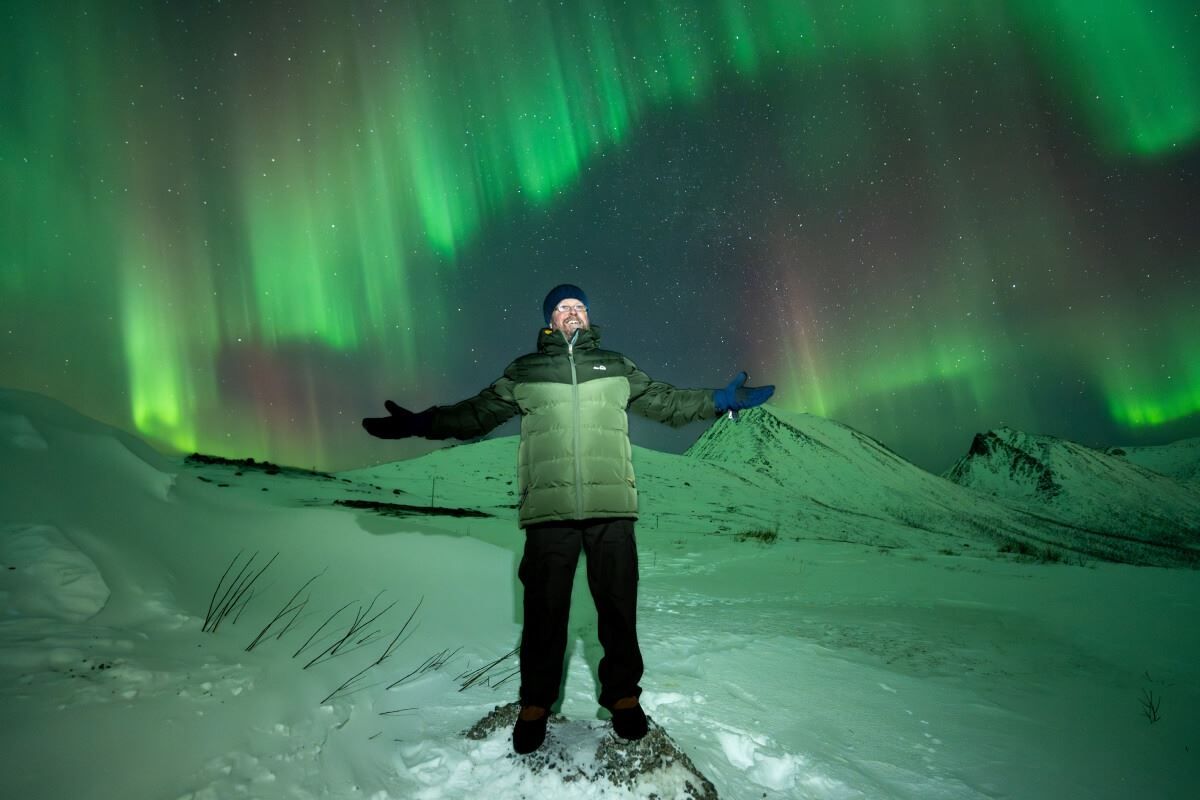 A guest is surrounded by the Aurora Borealis